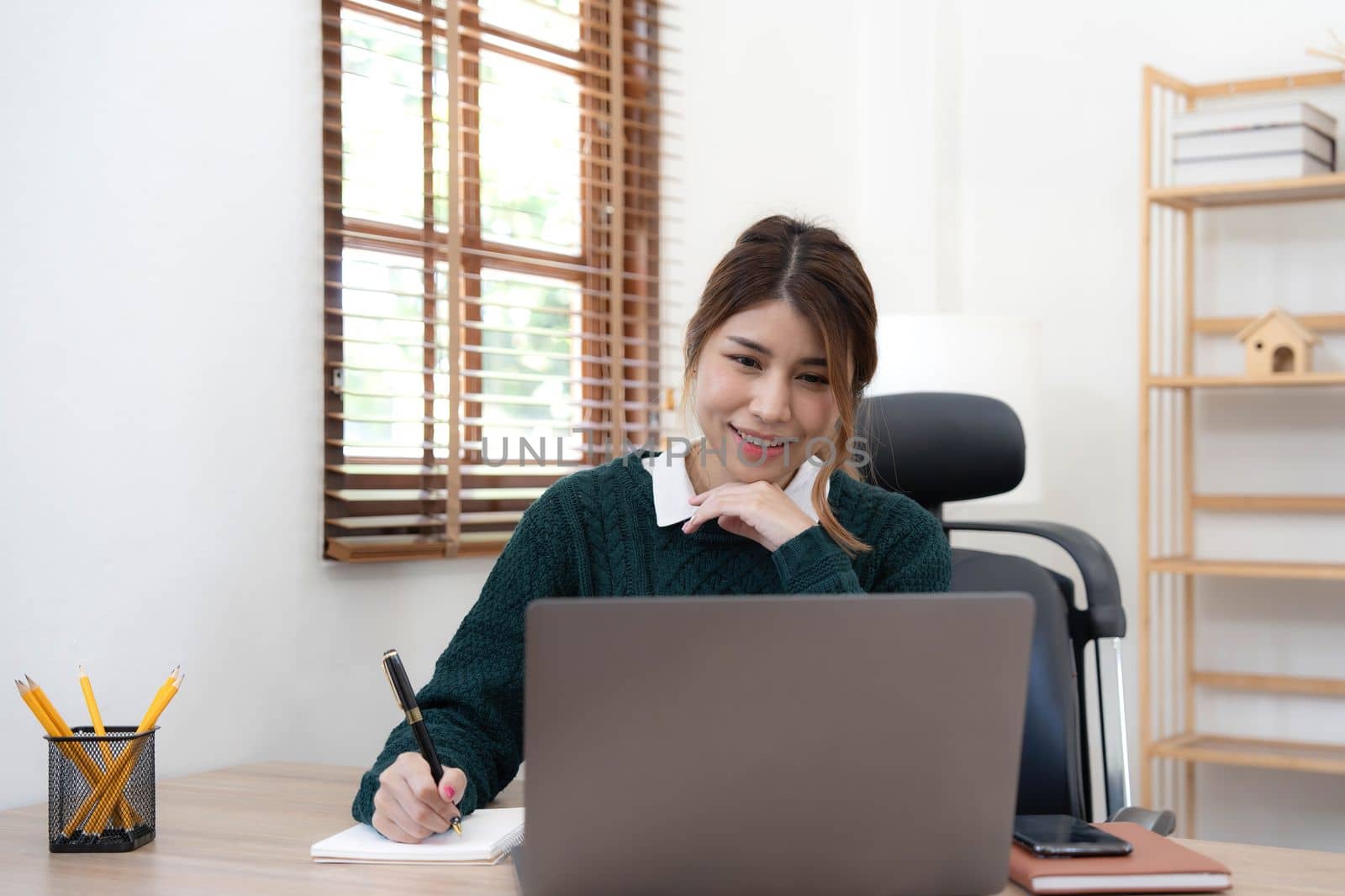 Portrait of smiling beautiful business asian young woman working in office use computer with copy space