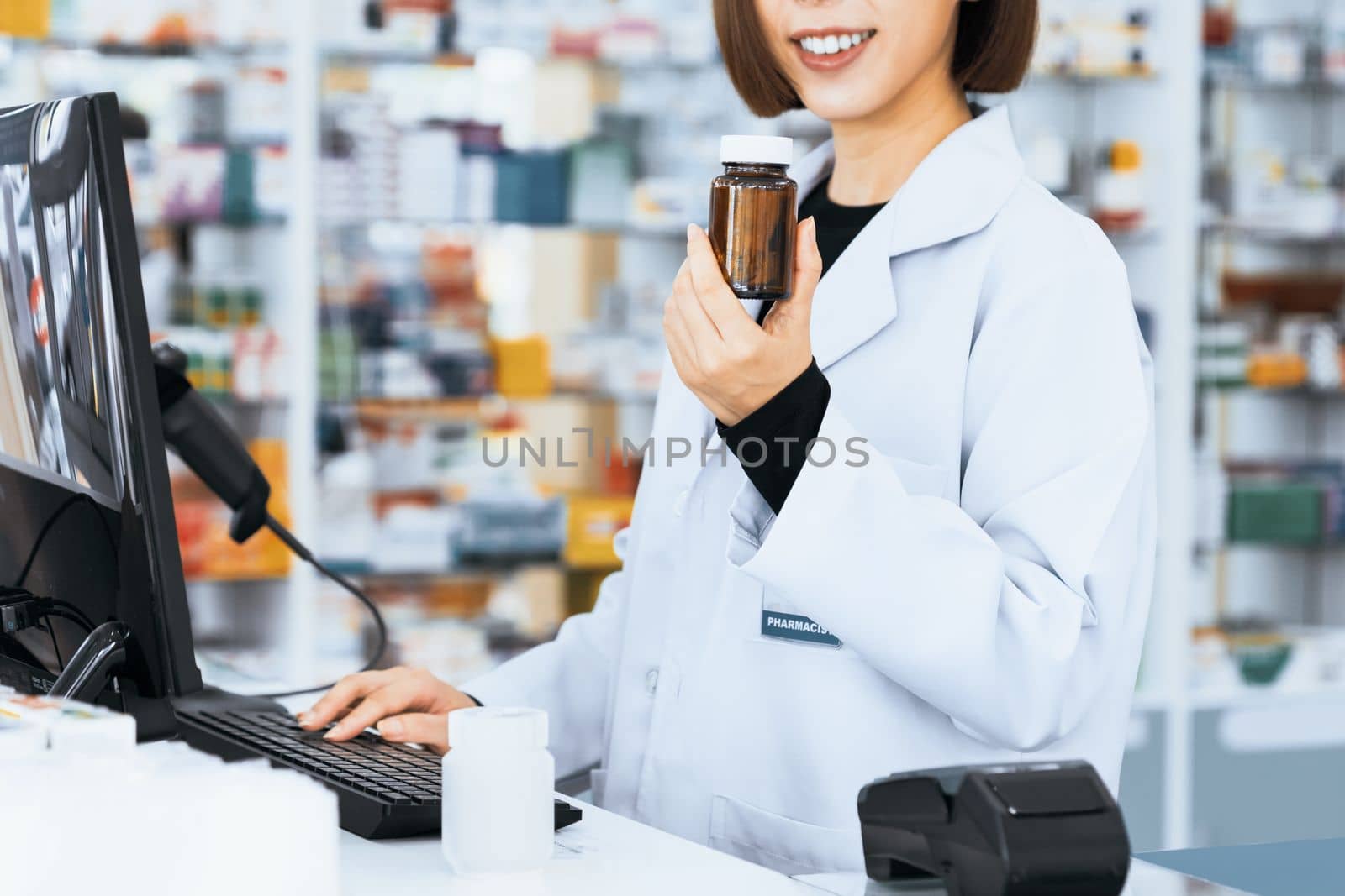 Closeup portrait of young asian pharmacist pill bottle at qualified pharmacy. by biancoblue