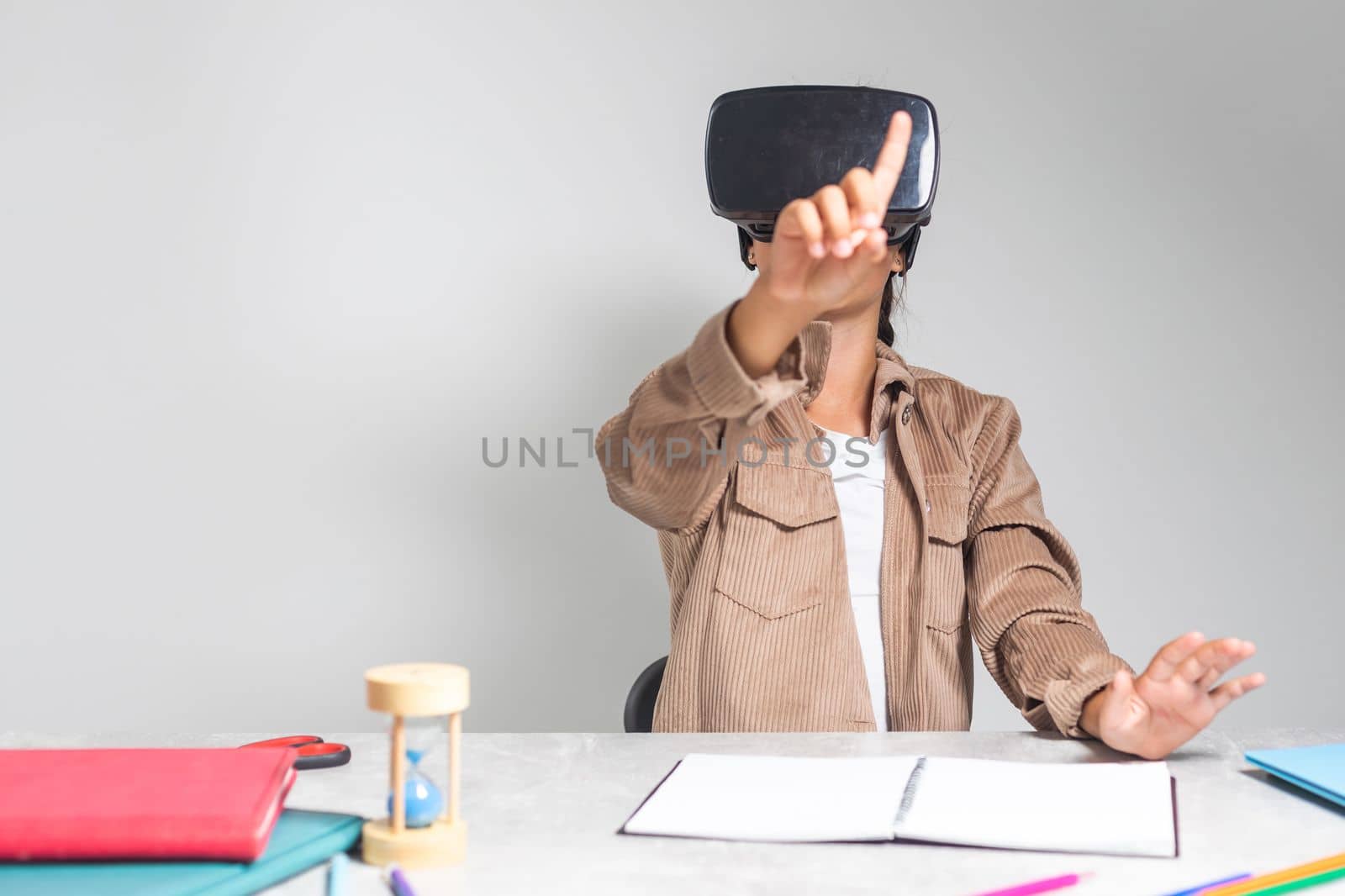 Little girl using VR glasses at home for learning. Modern education science concept.