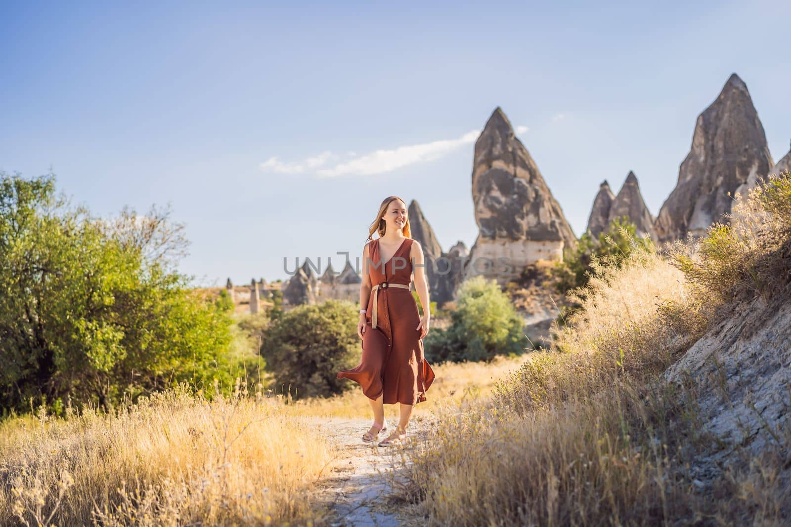 Woman tourist on background of Unique geological formations in Love Valley in Cappadocia, popular travel destination in Turkey.