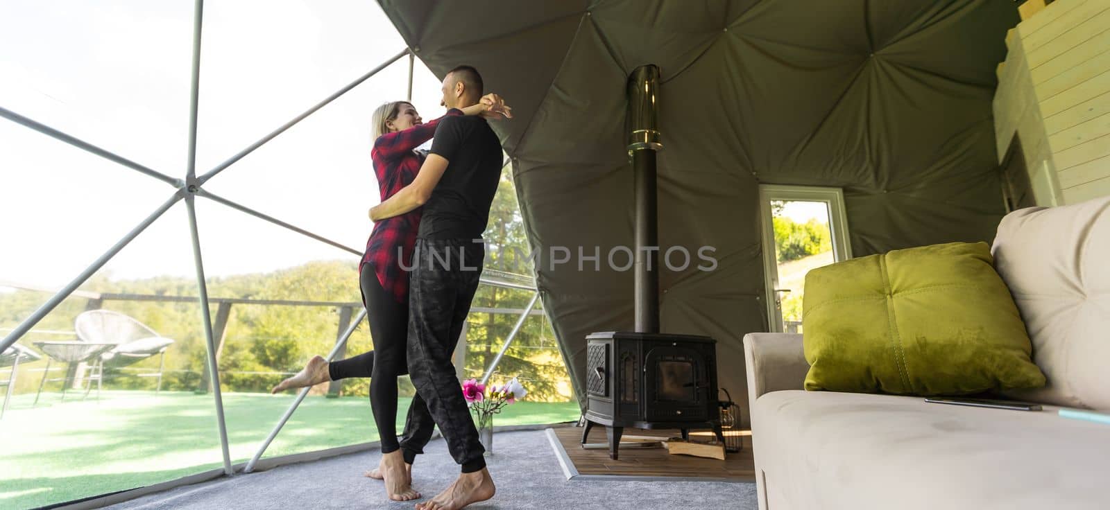 couple looking at nature from geo dome tents. Green, blue, orange background. Cozy, camping, glamping, holiday, vacation lifestyle concept. Scenic outdoors cabin by Andelov13