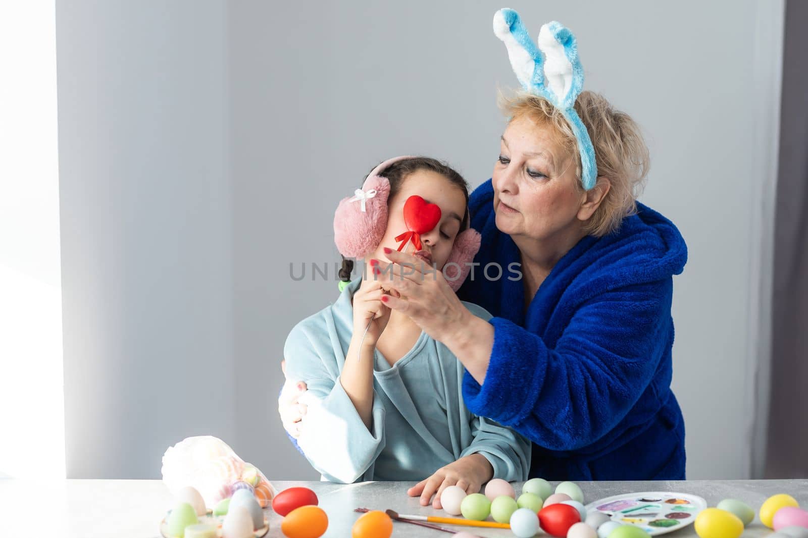 grandmother with granddaughter play with easter eggs, easter time to paint eggs.