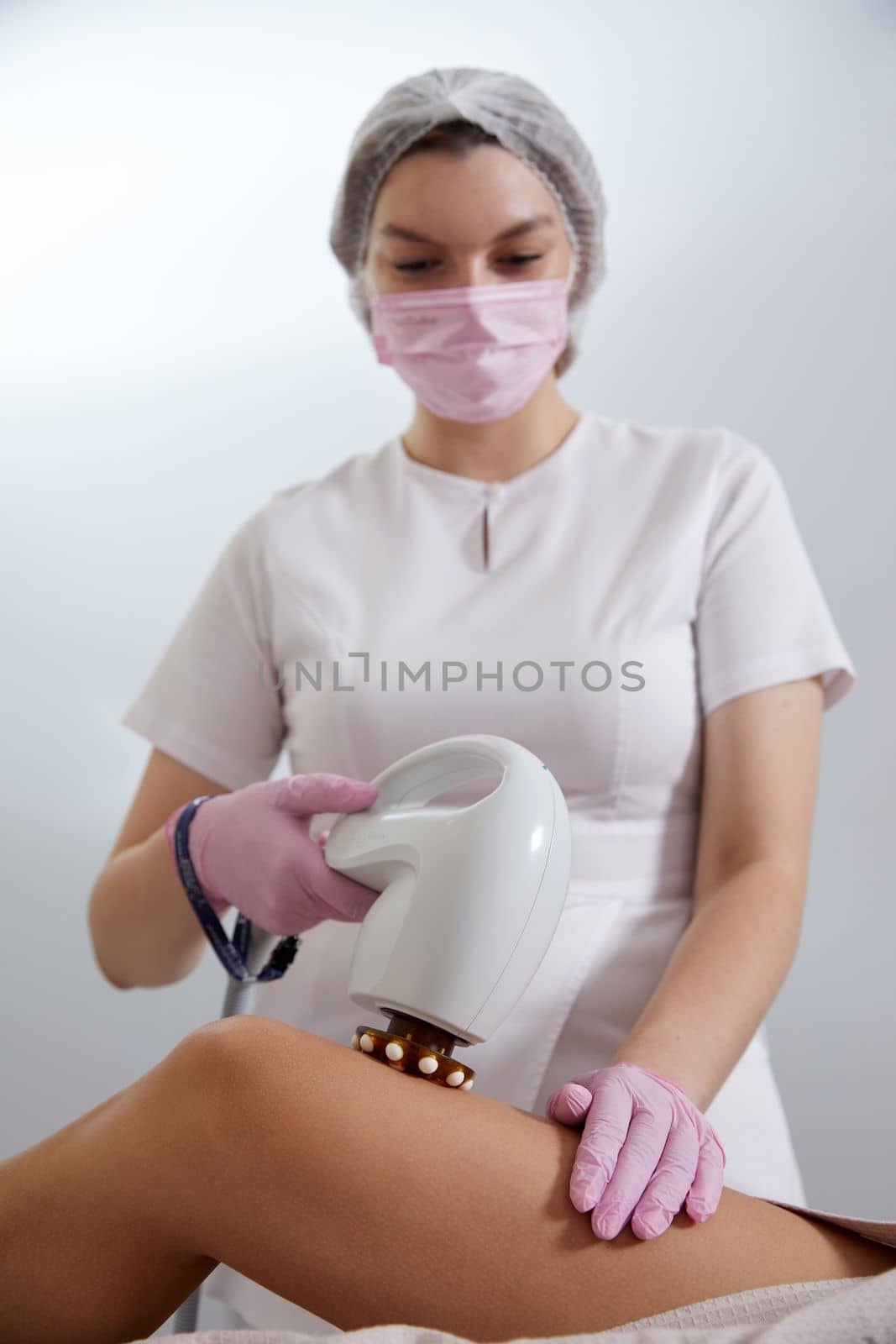Woman is receiving the laser cellulite removal in beauty salon by Mariakray