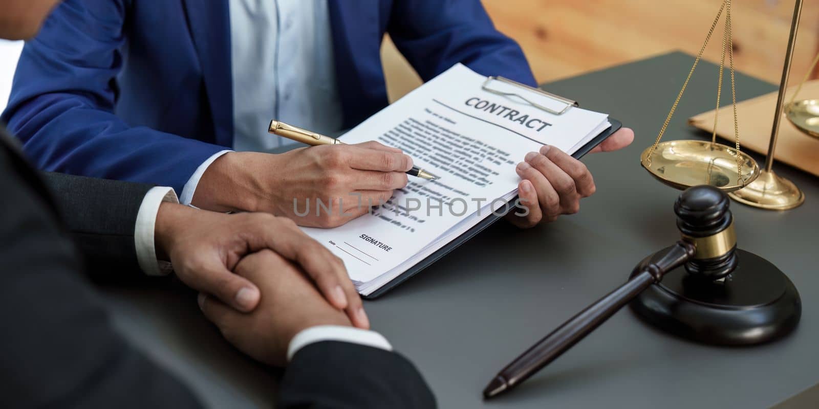 Business people and lawyers discussing contract papers with brass scale on wooden desk in office. Law, legal services, advice, Justice concept.