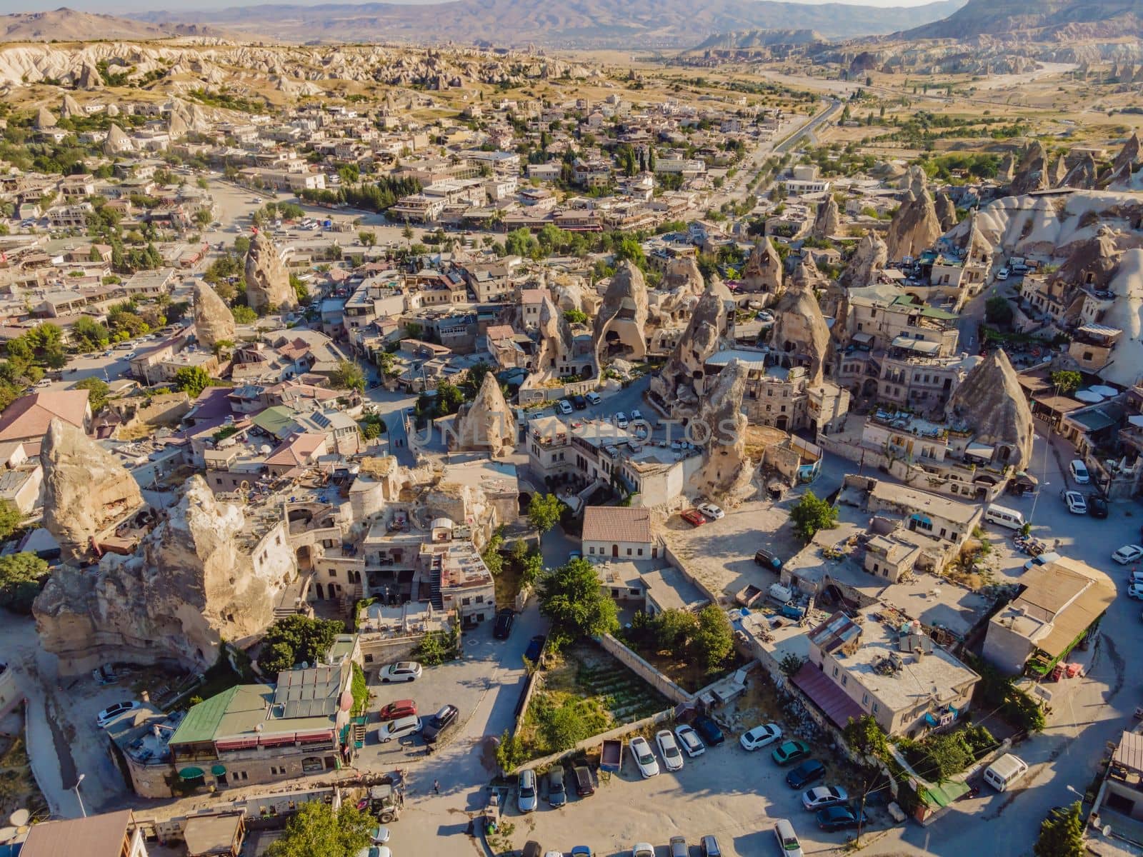 Colorful hot air balloons flying over at fairy chimneys valley in Nevsehir, Goreme, Cappadocia Turkey. Spectacular panoramic drone view of the underground city and ballooning tourism. High quality.