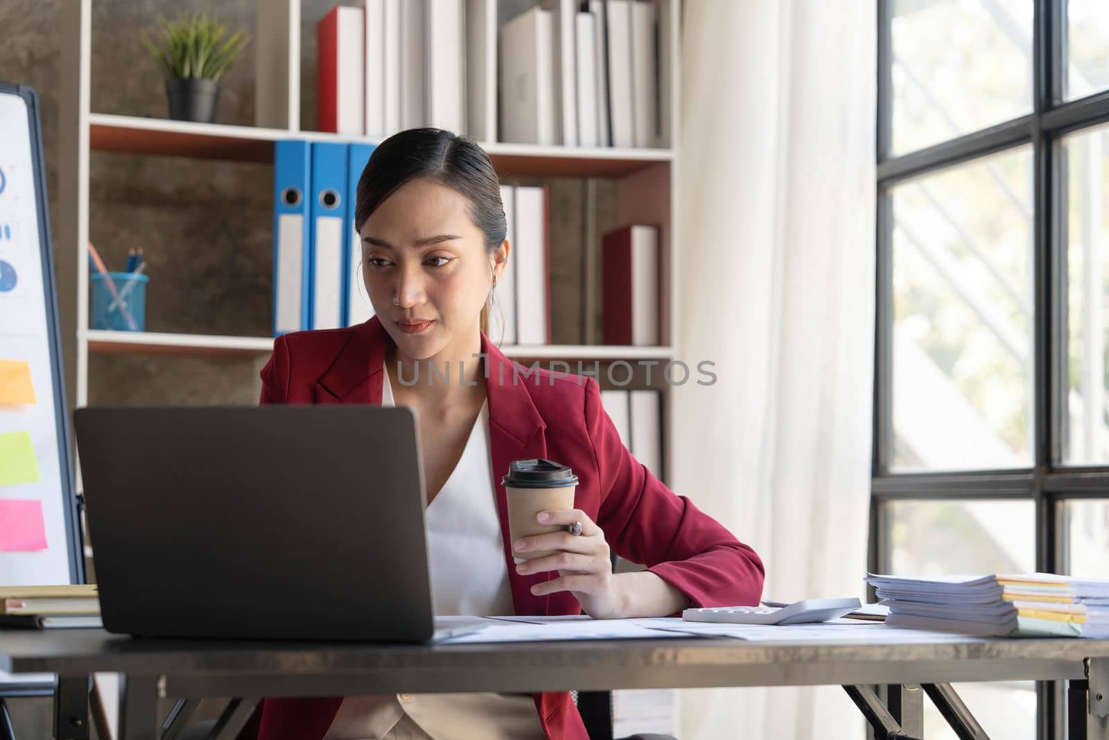 Beautiful young Asian girl working at a office space with a laptop. Concept of smart female business