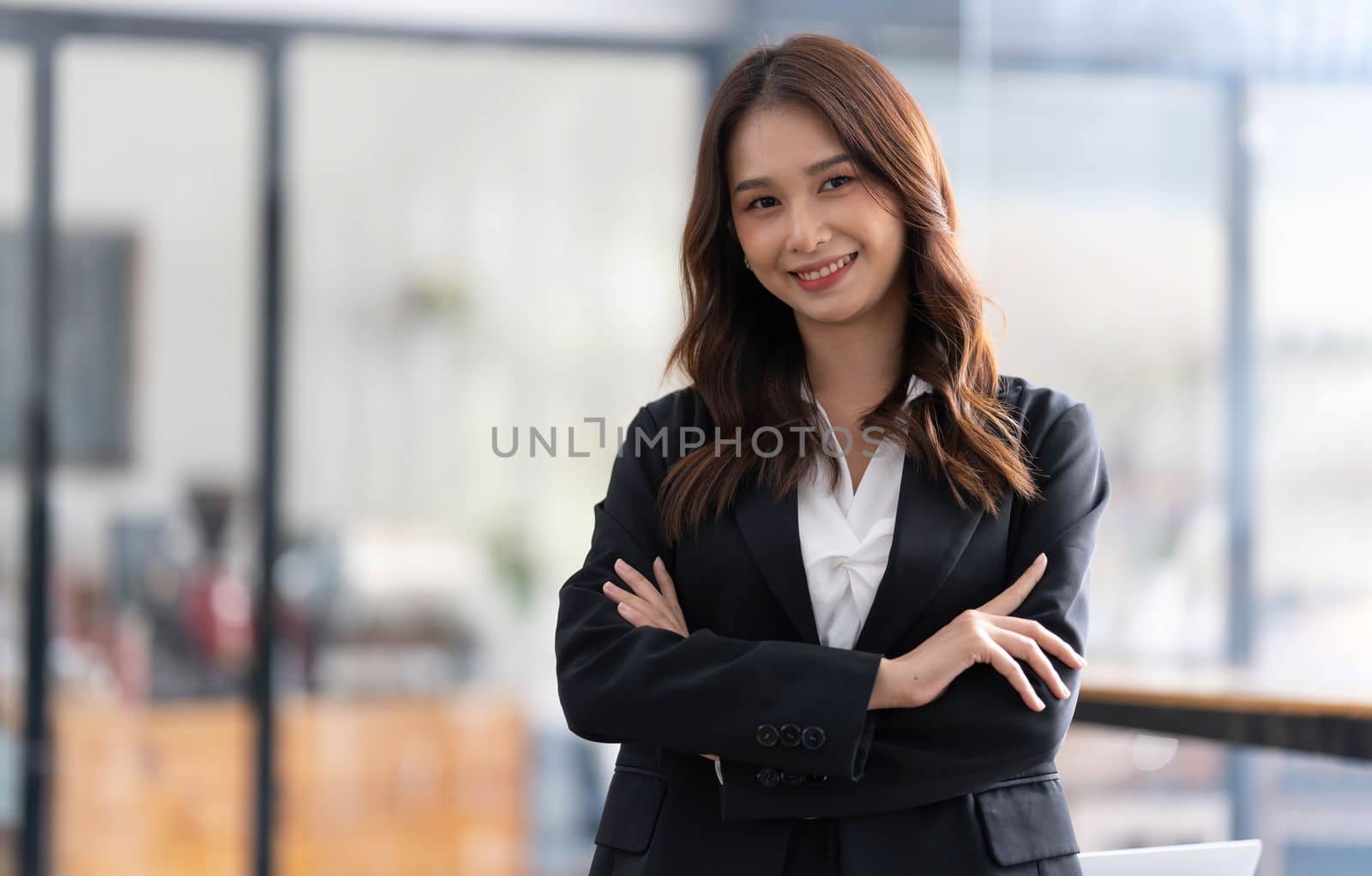 Charming Young Asian businesswoman standing in the office. Looking at camera...