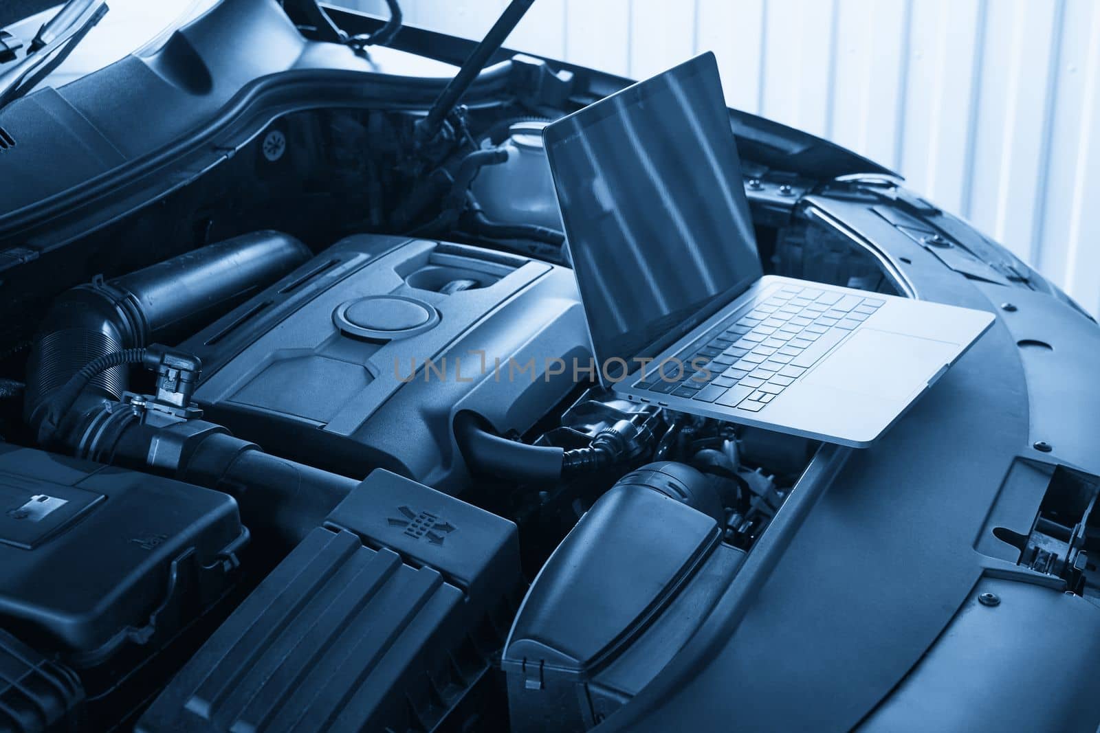 Services car engine machine concept, Automobile mechanic repairman checking a car engine with using computer diagnostics while repairing, car service and maintenance.