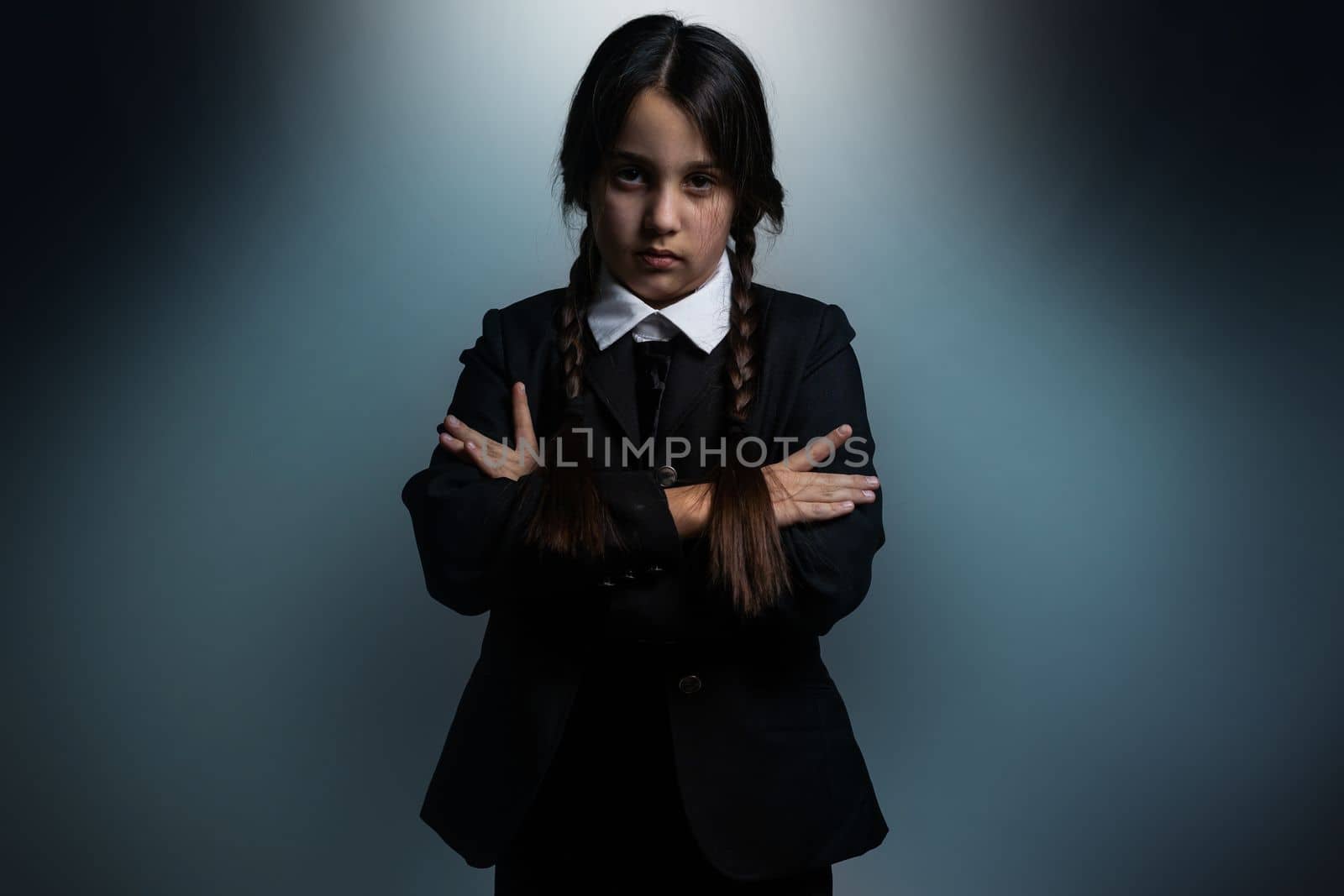 A girl with braids in a gothic style on a dark background