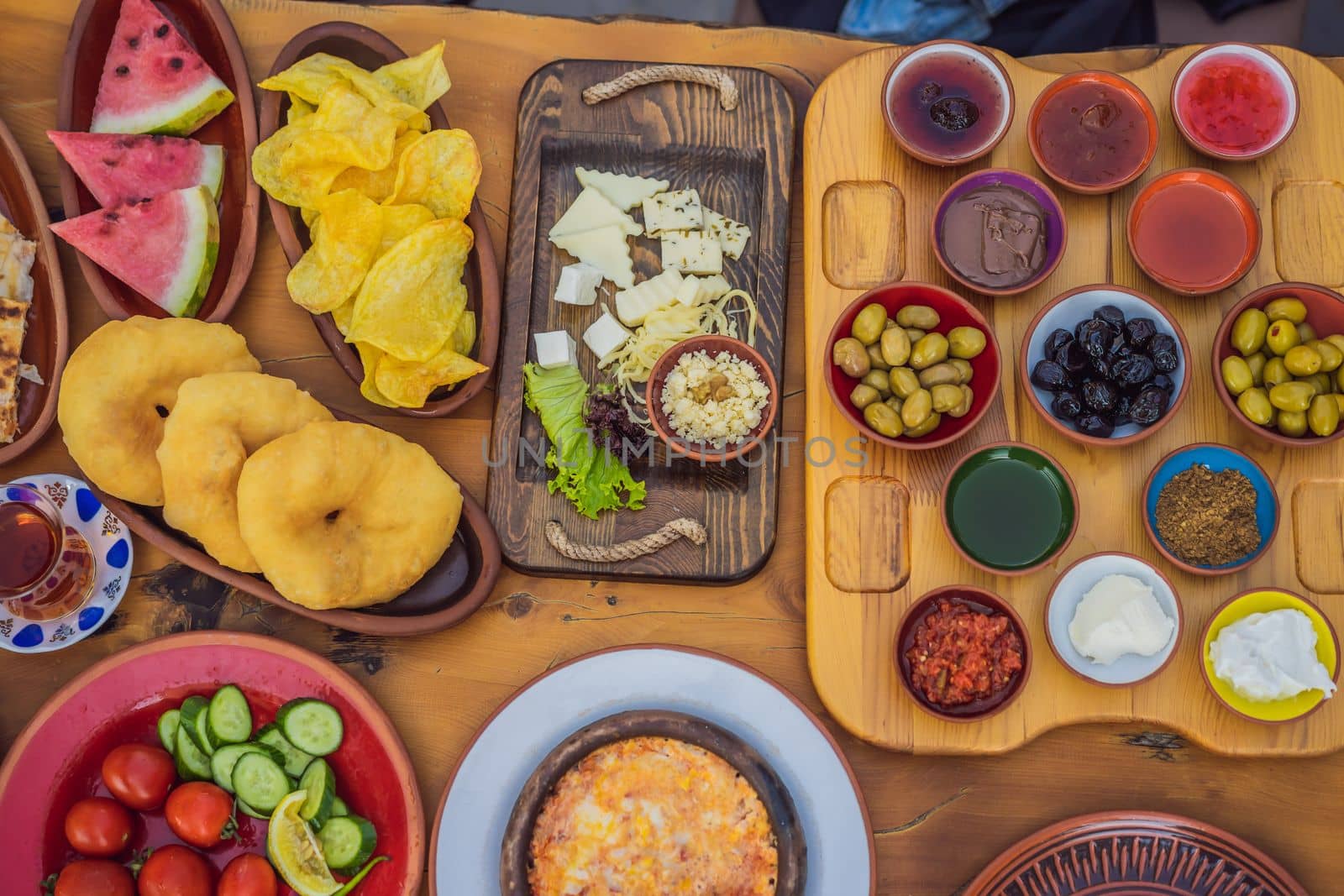 Turkish breakfast table. Pastries, vegetables, greens, olives, cheeses, fried eggs, spices, jams, honey, tea in copper pot and tulip glasses, wide composition by galitskaya