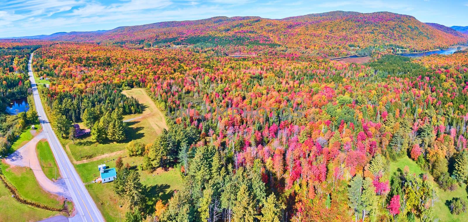 Aerial over road going through beautiful hills of peak fall foliage by njproductions