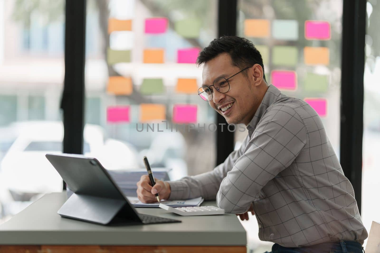 Pleasant positive businessman using digital tablet at home office.