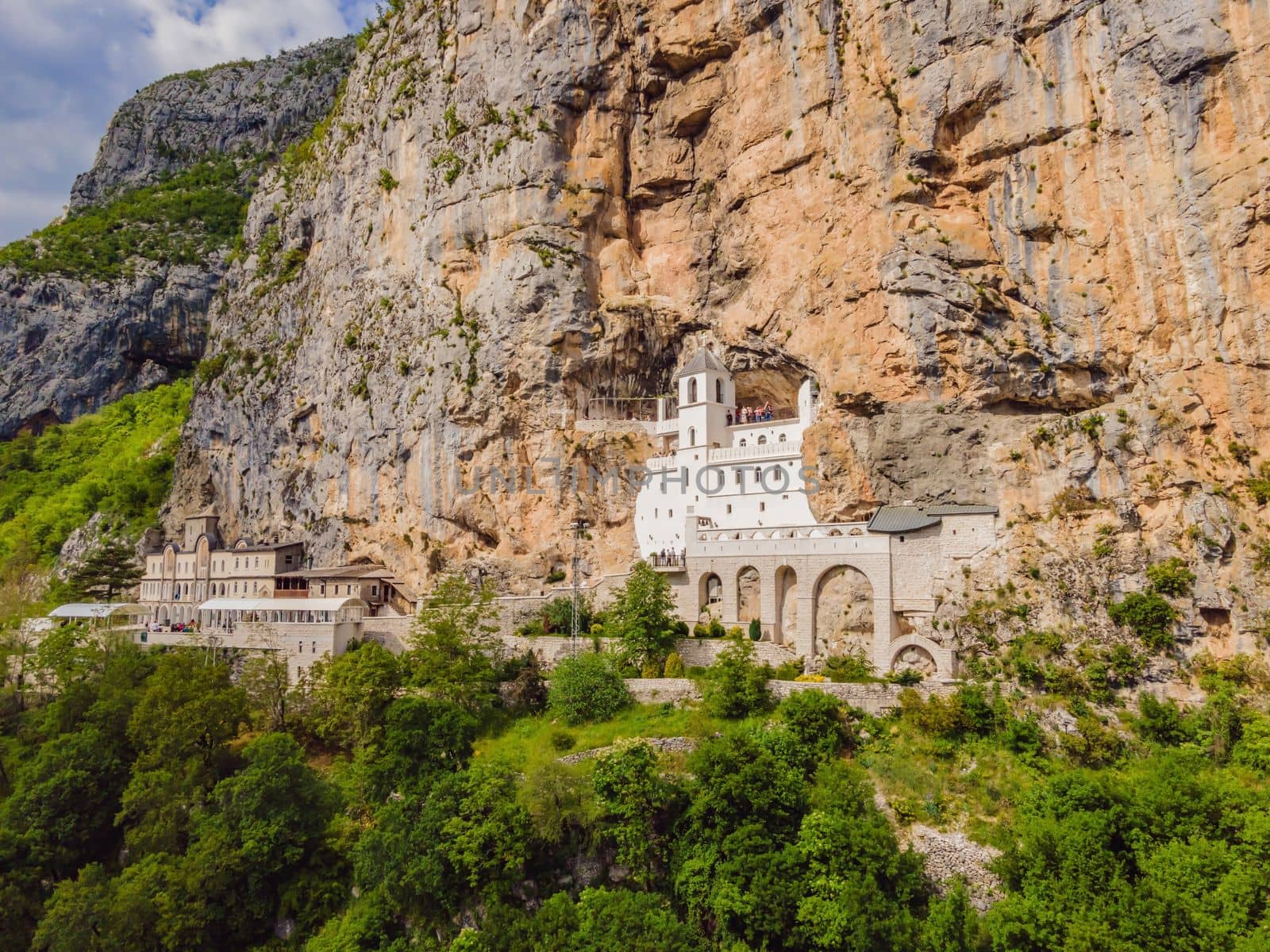 Monastery of Ostrog, Serbian Orthodox Church situated against a vertical background, high up in the large rock of Ostroska Greda, Montenegro. Dedicated to Saint Basil of Ostrog by galitskaya