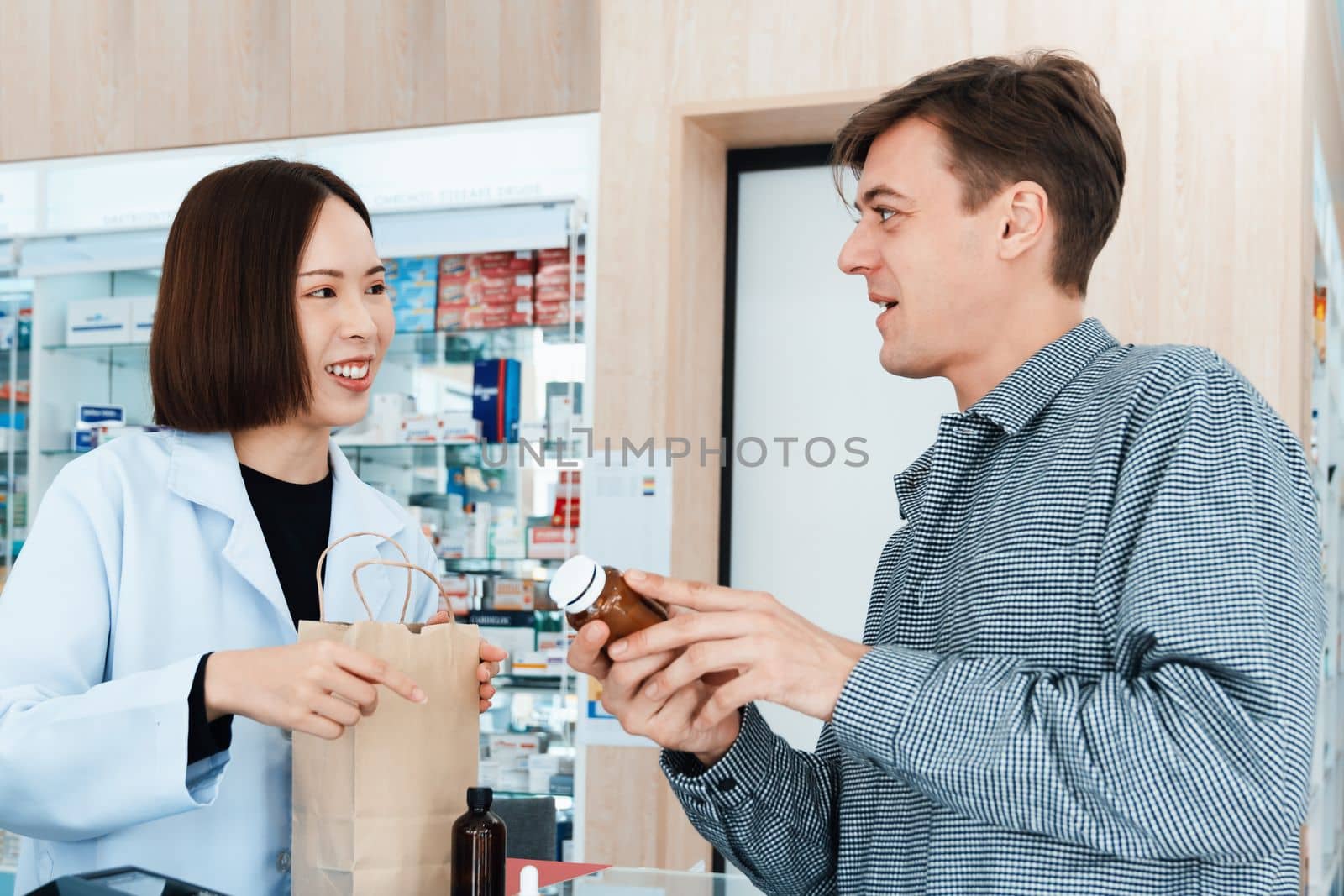 Professional pharmacist advise or explain property of qualified medical product to customer in pharmacy, druggist answer to client healthcare inquiry, medical service and consultation concept.