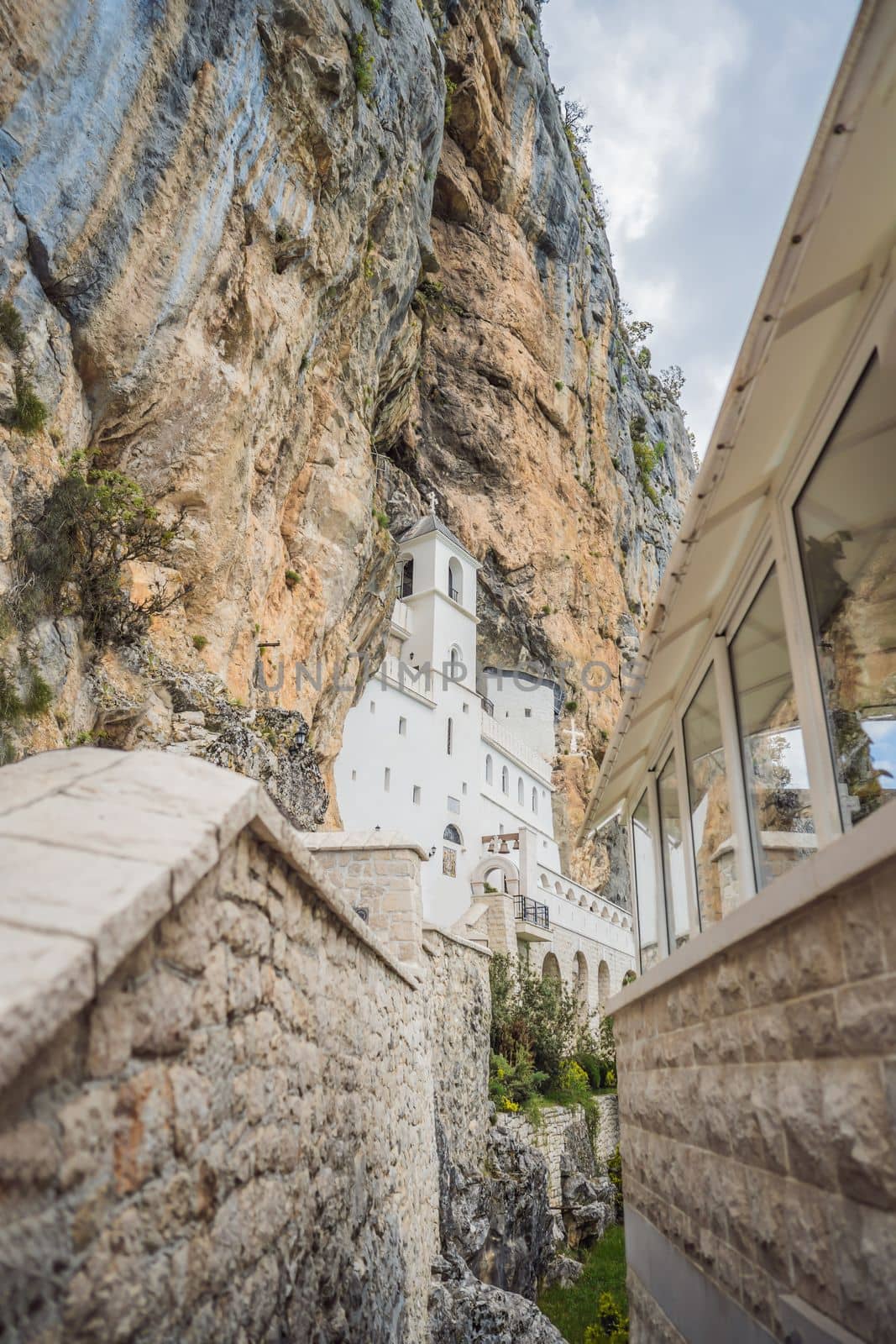 Monastery of Ostrog, Serbian Orthodox Church situated against a vertical background, high up in the large rock of Ostroska Greda, Montenegro. Dedicated to Saint Basil of Ostrog by galitskaya