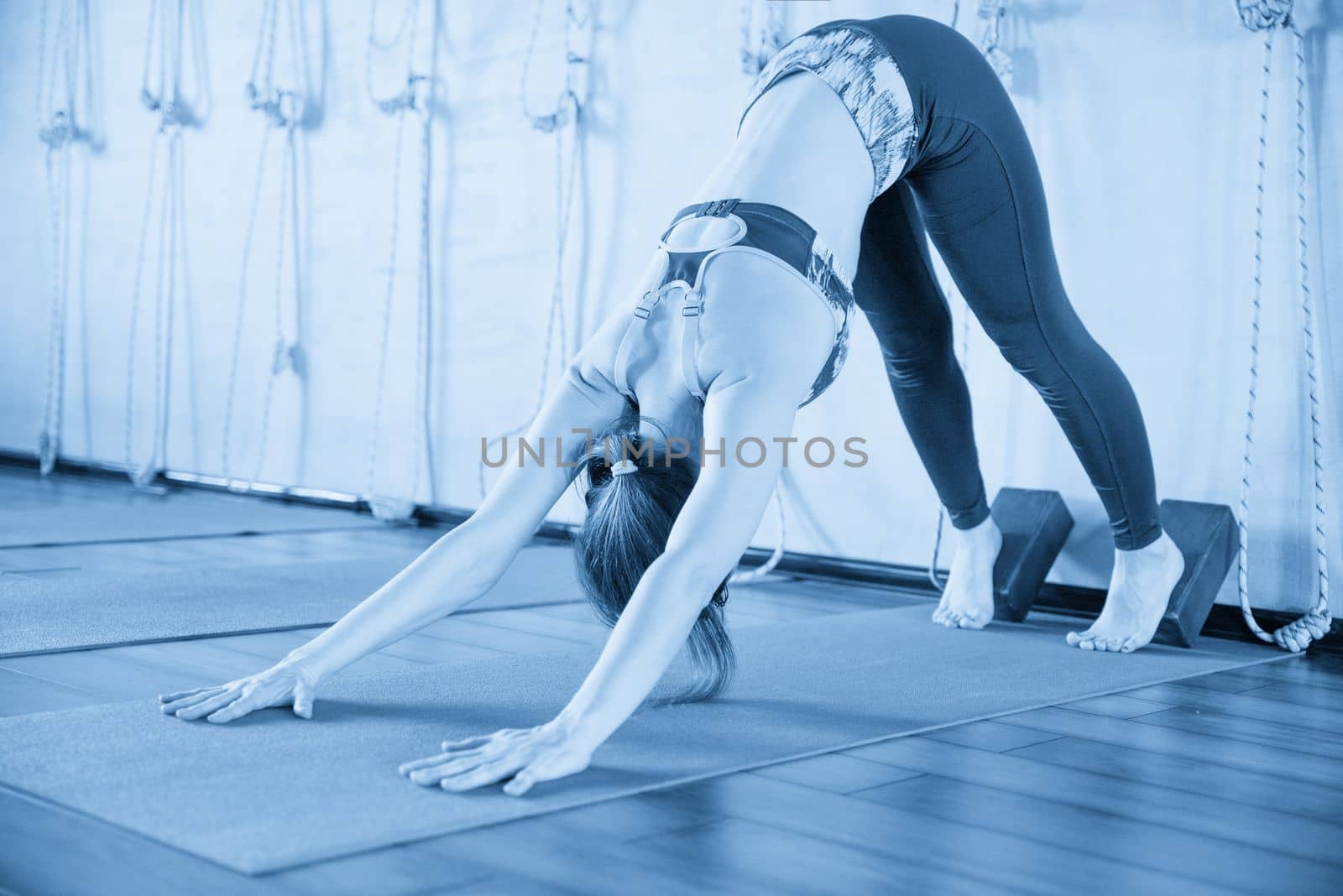 Portrait of a beautiful young woman sitting in yoga pose at the beach