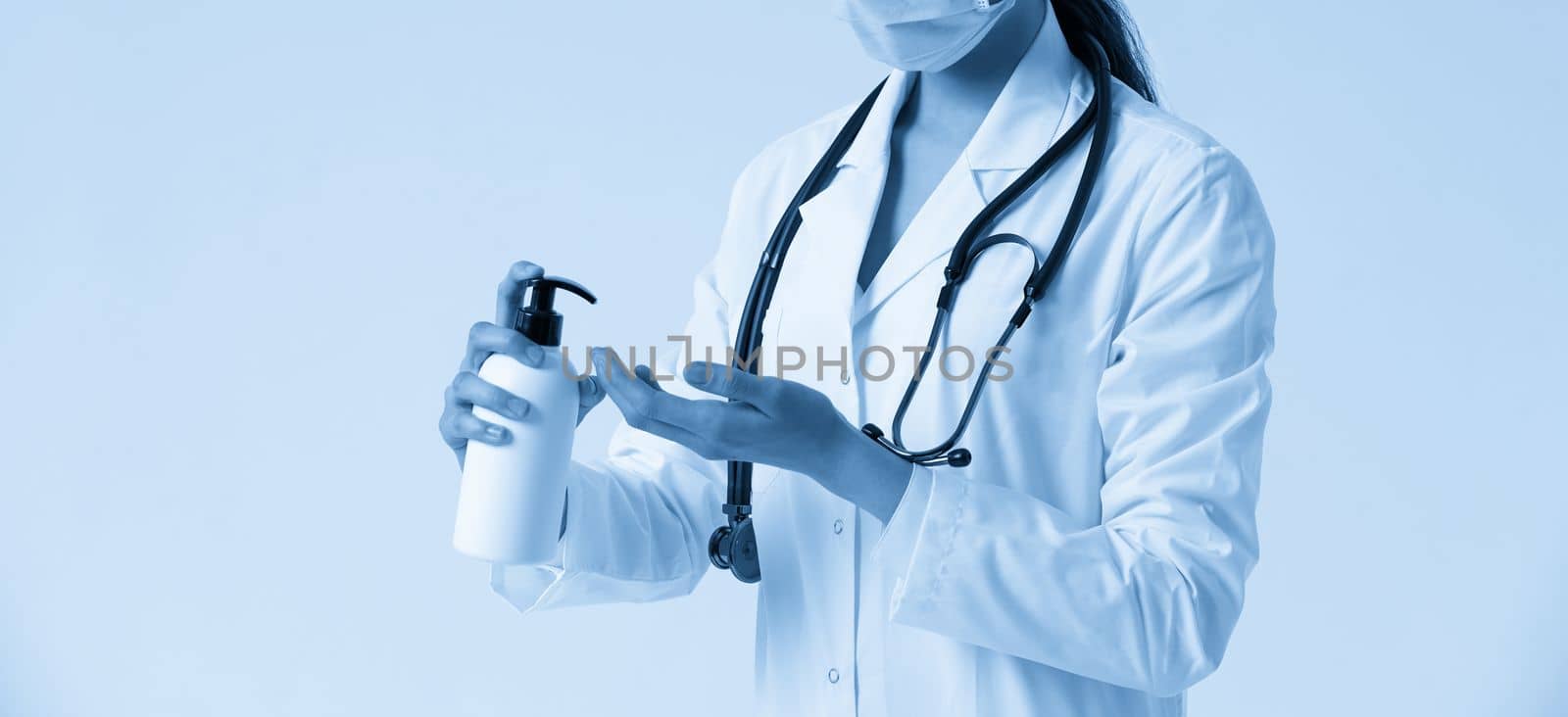 doctor applying antibacterial spray on hand in hospital