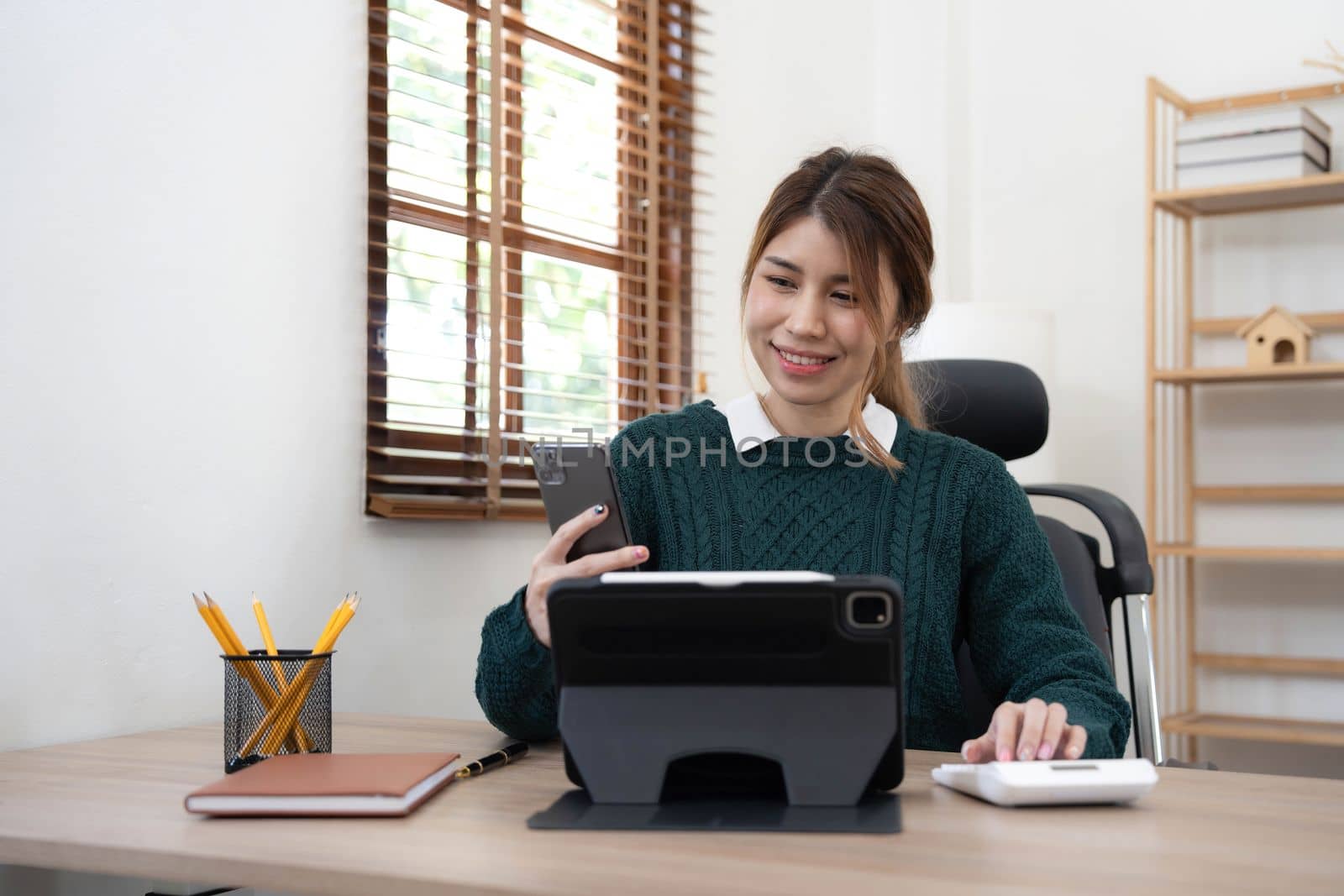 Portrait of smiling beautiful business asian young woman working in office use computer with copy space