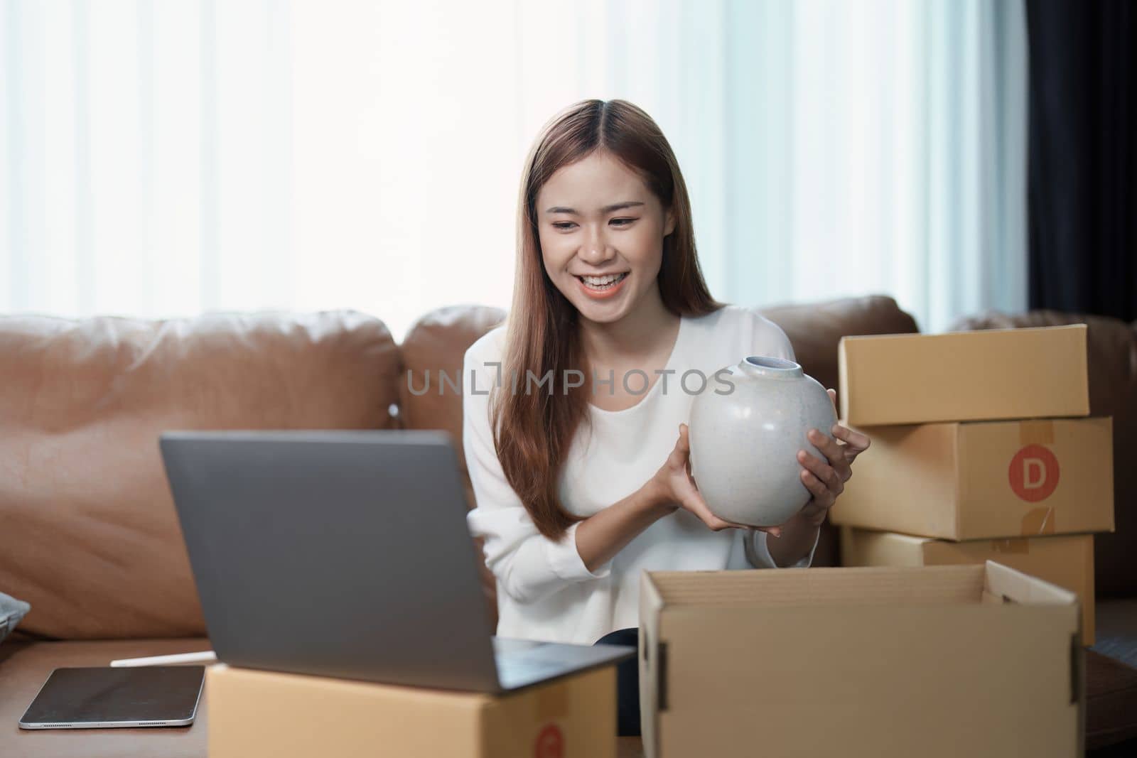 Starting small business entrepreneur of independent young Asian woman online seller using a computer showing products to a customer before making a purchase decision. SME delivery concept.