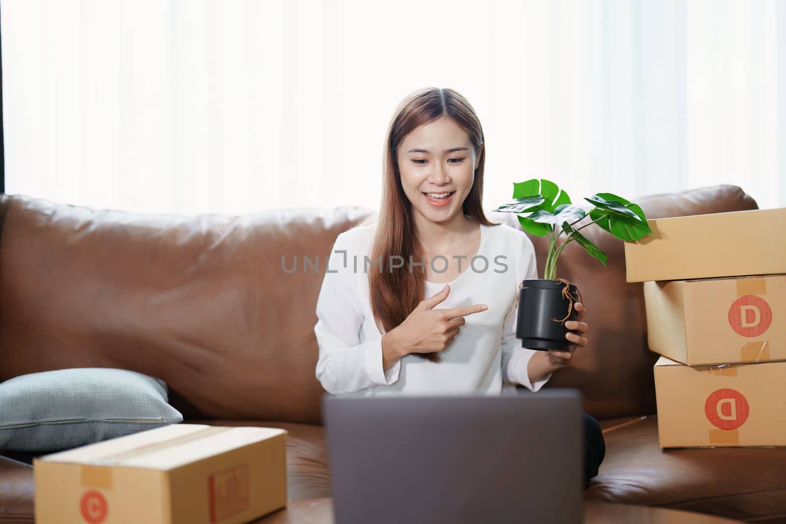 Starting small business entrepreneur of independent young Asian woman online seller using a computer showing products to a customer before making a purchase decision. SME delivery concept by Manastrong