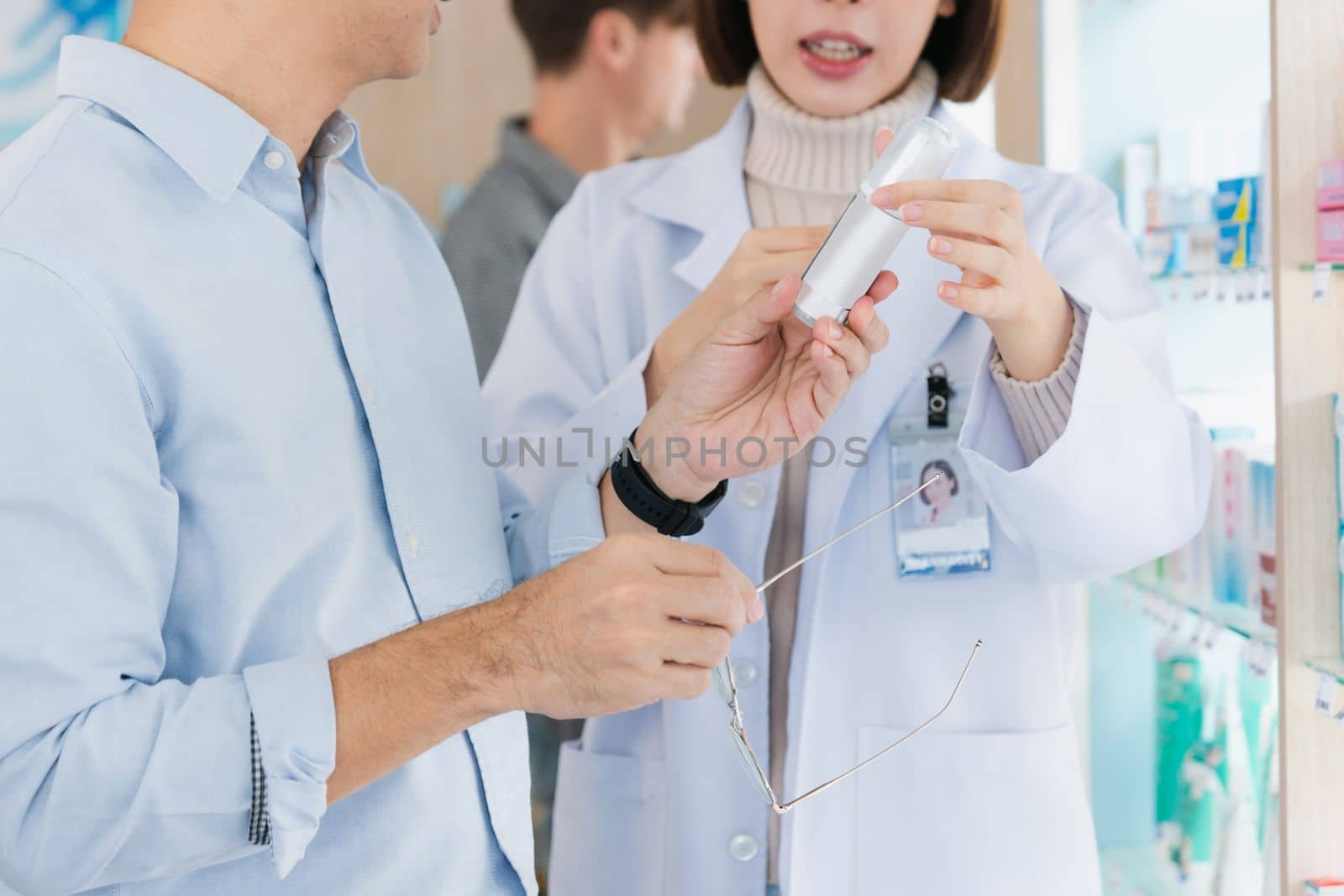 Closeup professional pharmacist advise or explain property of qualified medical product to customer in pharmacy, druggist answer to client healthcare inquiry, medical service and consultation concept.