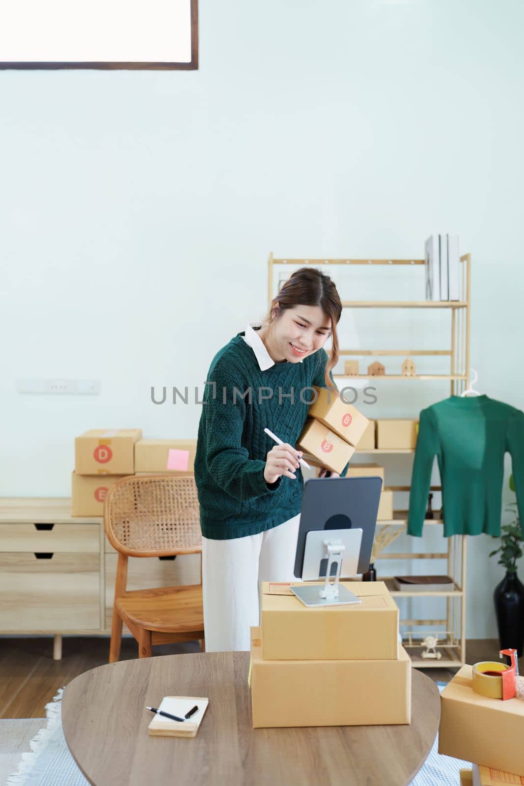 Starting small business entrepreneur of independent Asian female online seller packing products to send to customers and SME delivery concept by Manastrong