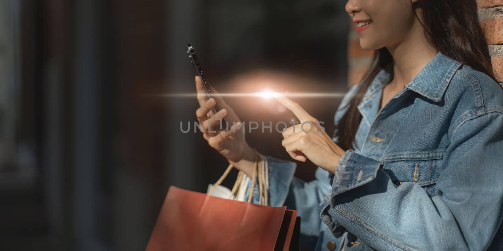 Asian fashionable woman walking at shopping mall with shopping bags while flash sale promotion.