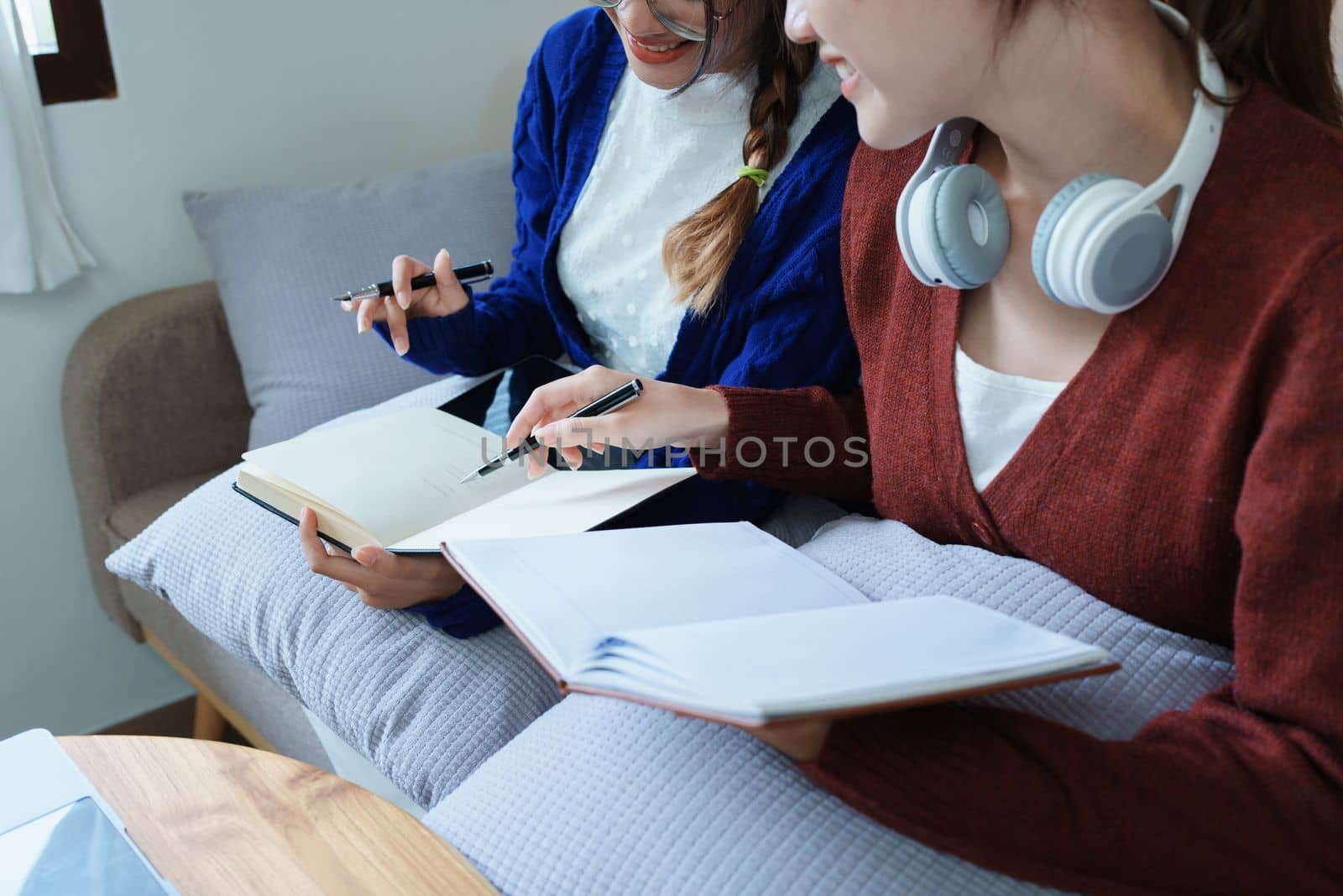 lgbtq, lgbt concept, homosexuality, portrait of two asian women posing happy together and loving each other while playing computer laptop with notebook for learning online by Manastrong