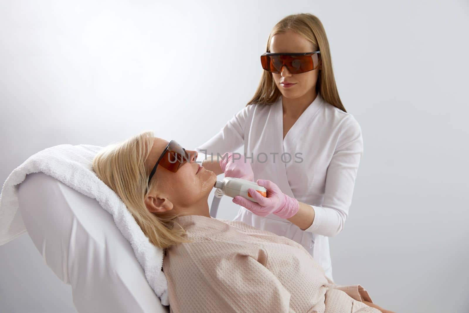 Woman receiving laser treatment in modern cosmetology clinic by Mariakray
