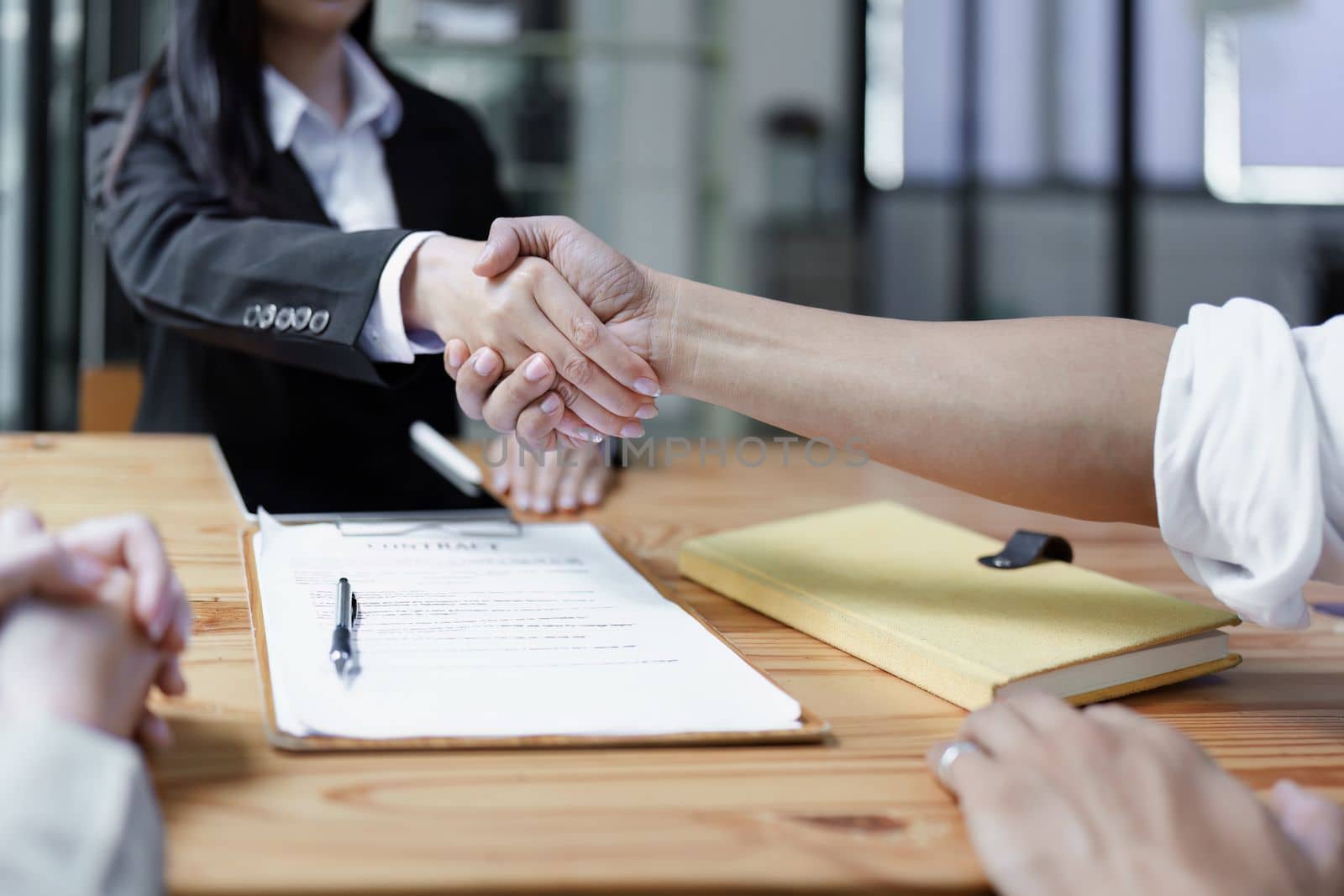 Law, consultation, agreement, contract, lawyer or attorney shakes hands to agree on the client's offer to be hired to fight the parties in court. by Manastrong