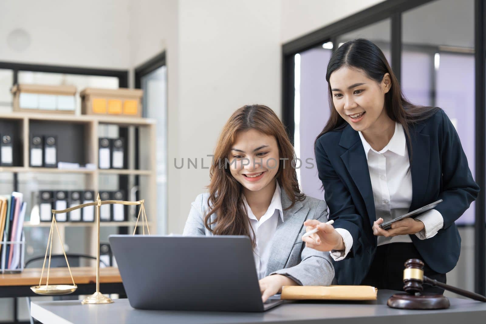 Business law concept, Lawyer business lawyers are consulting lawyers for women entrepreneurs to file copyright lawsuit with laptop and tablet by wichayada