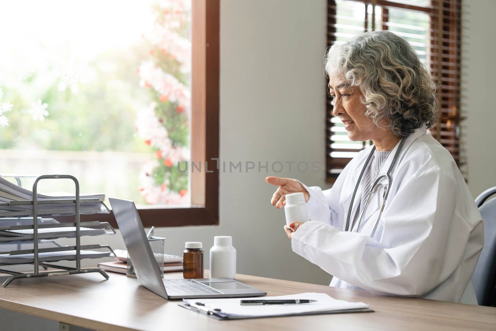 Asian senior doctor hospital medical medicine health care clinic office. using laptop computer...