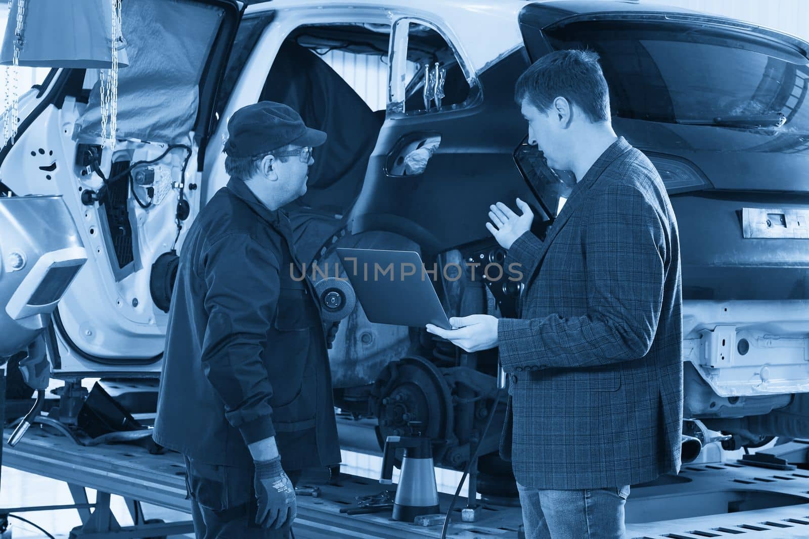 Manager In Auto Repair Service with mechanic on background