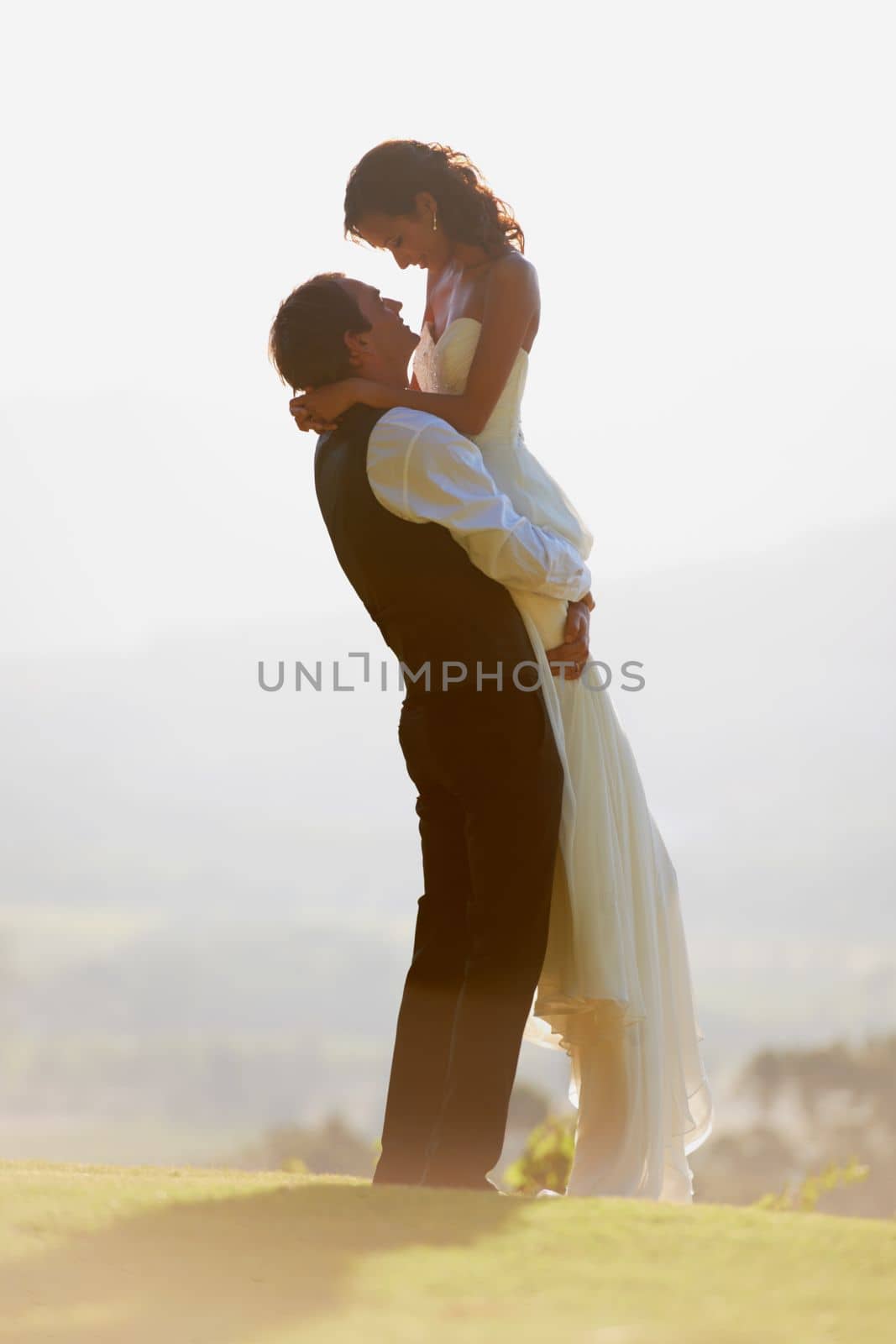 The first day of their lives together. A groom lifting his bride in the air