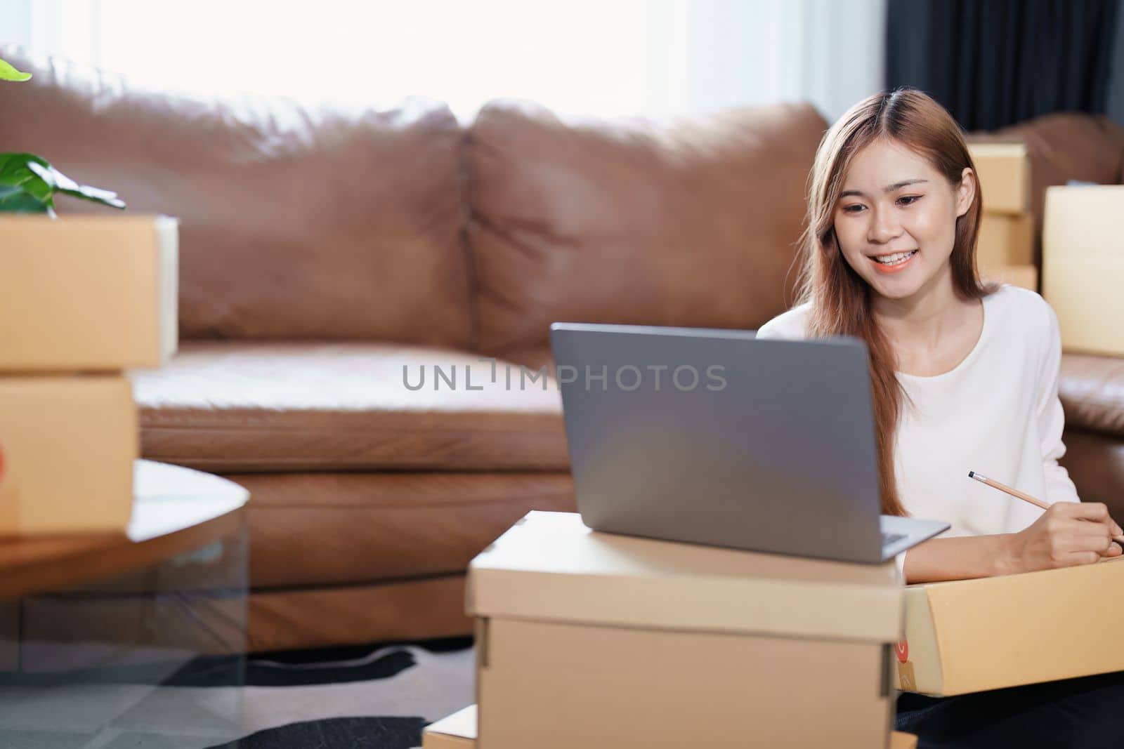 Starting small business entrepreneur of independent Asian female online seller packing products to send to customers and SME delivery concept.