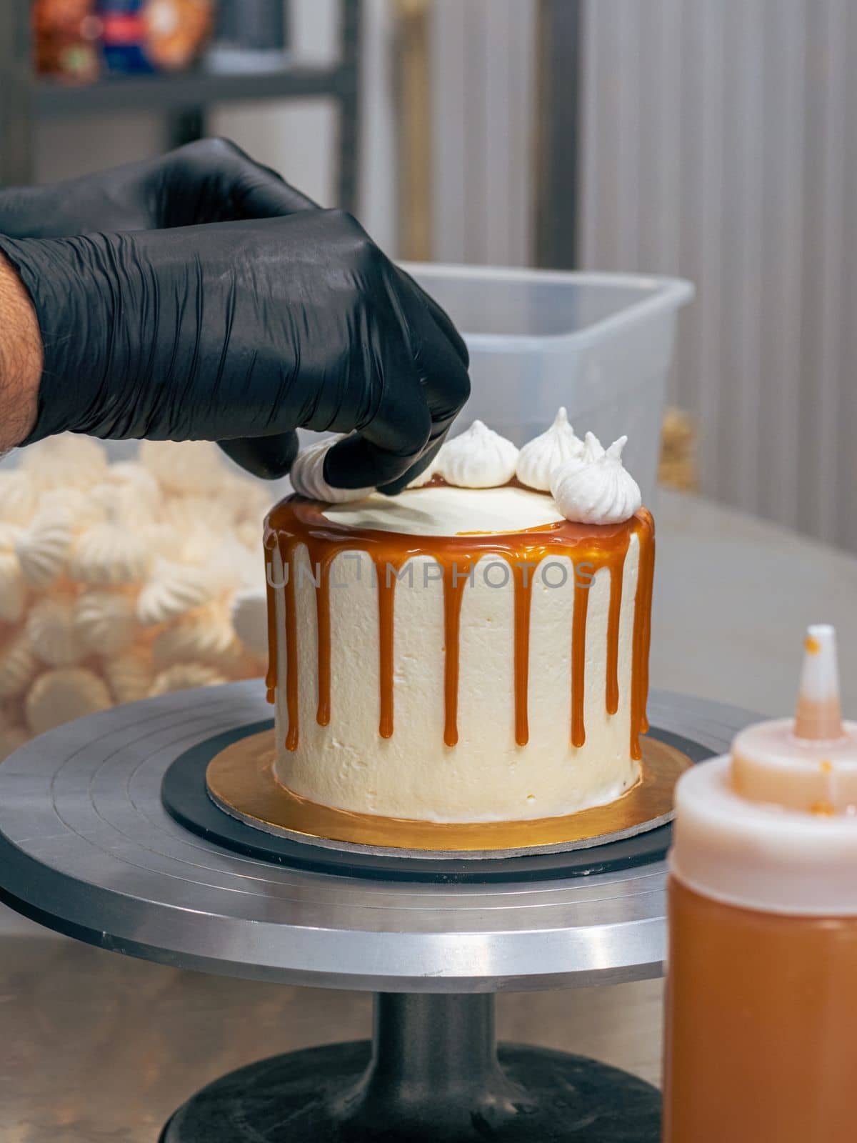 professional baker decorating a chocolate and cream cake with salty caramel