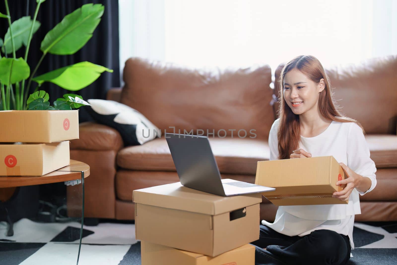 Starting small business entrepreneur of independent Asian female online seller packing products to send to customers and SME delivery concept.