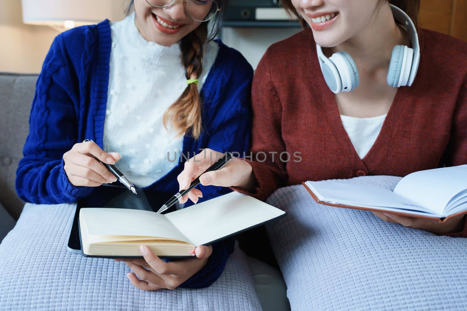lgbtq, lgbt concept, homosexuality, portrait of two asian women posing happy together and loving each other while playing computer laptop with notebook for learning online by Manastrong