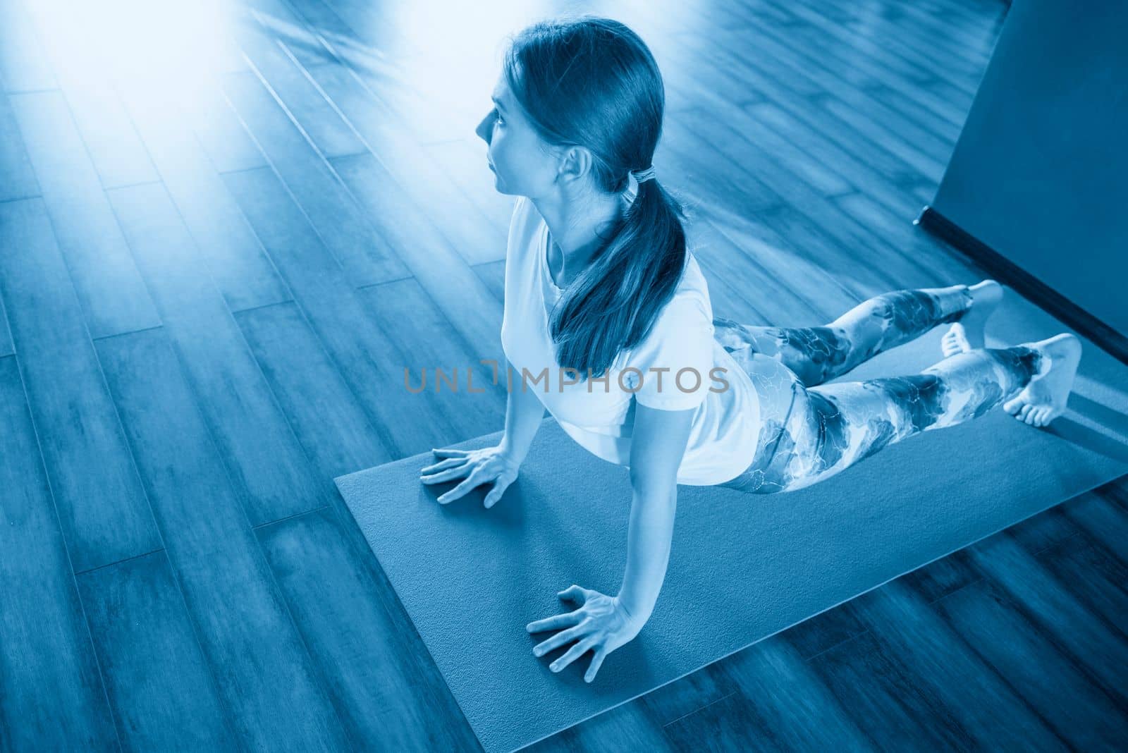 fitness, sport, training and lifestyle concept - smiling woman stretching on mat in gym