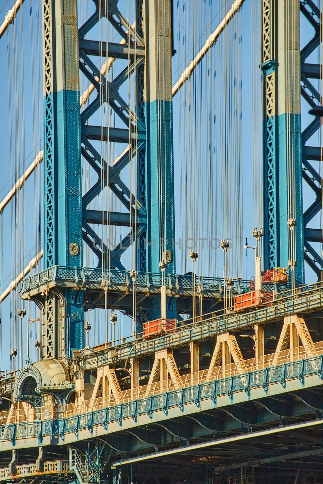 Image of Detail of beautiful Manhattan bridge section in sun with blue and white paint from Brooklyn