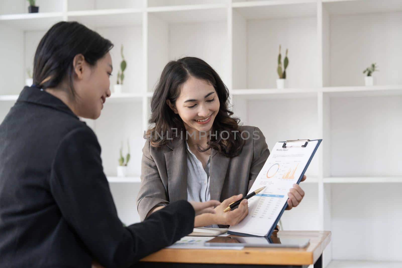 Two business leaders talk about charts, financial graphs showing results are analyzing and calculating planning strategies, business success building processes by wichayada
