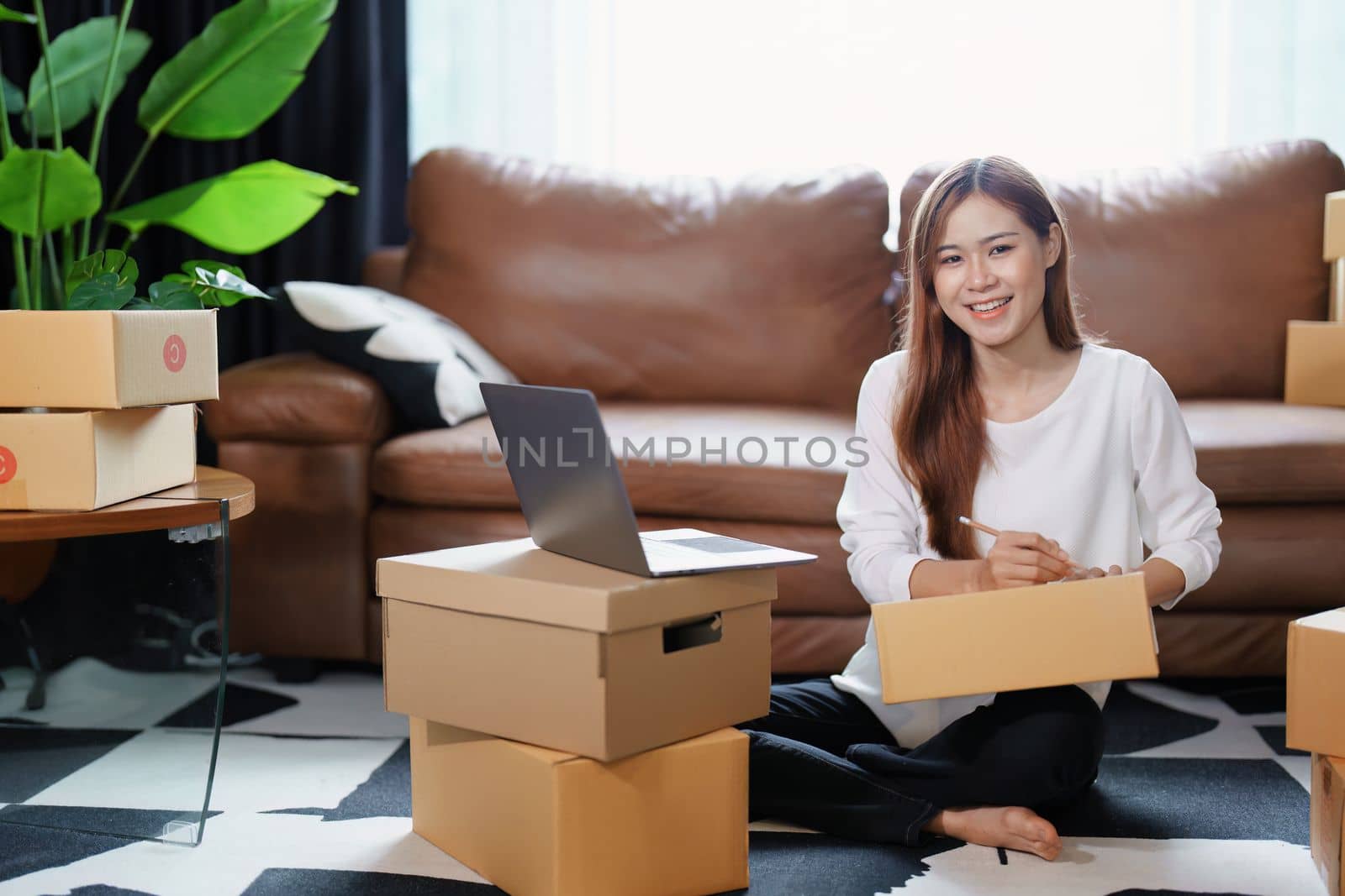 Starting small business entrepreneur of independent Asian female online seller packing products to send to customers and SME delivery concept.