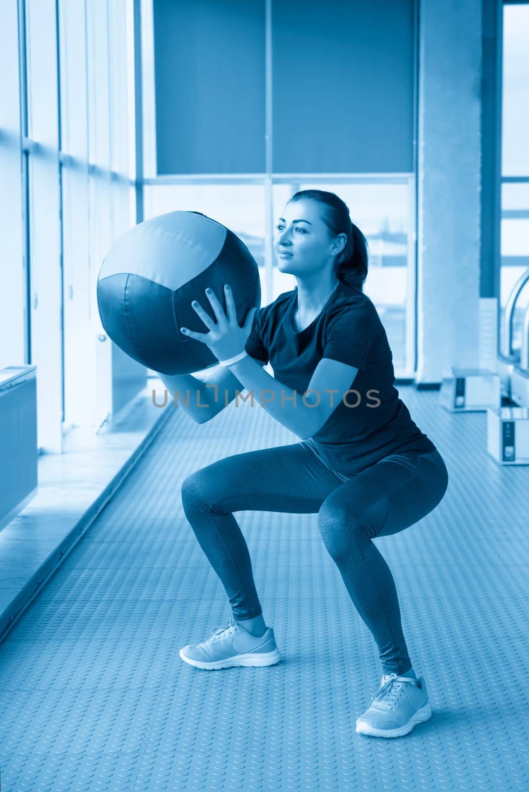 woman in gym relaxing with medicine ball by Mariakray