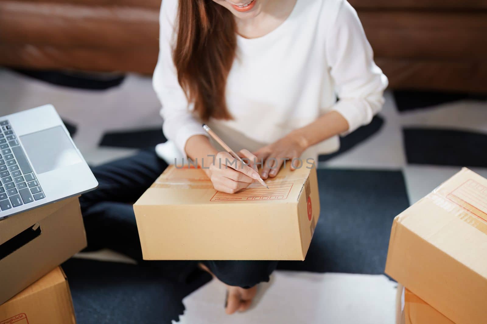 Starting small business entrepreneur of independent Asian female online seller packing products to send to customers and SME delivery concept by Manastrong