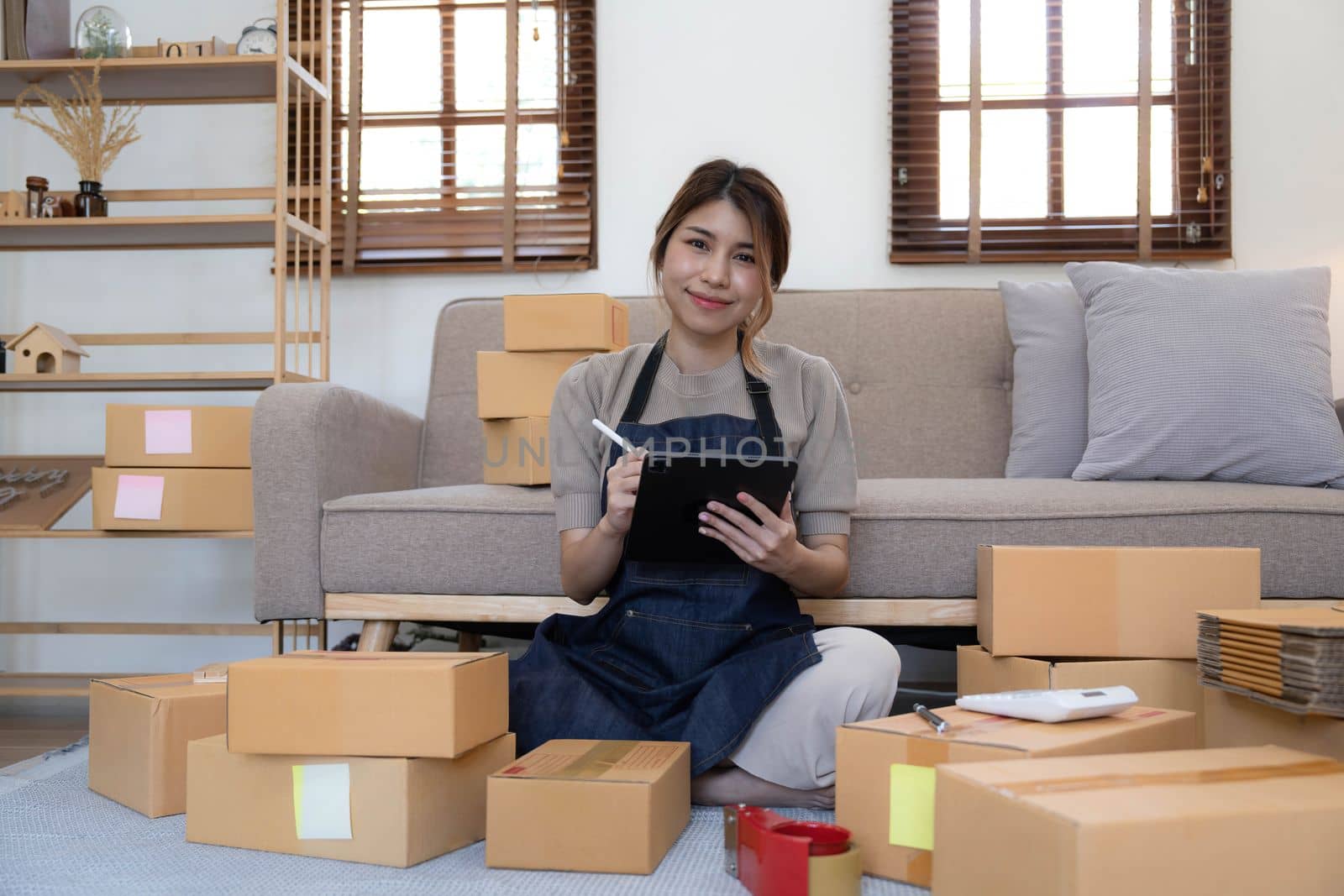 Portrait of Starting small businesses SME owners female entrepreneurs working on receipt box and check online orders to prepare to pack the boxes, sell to customers