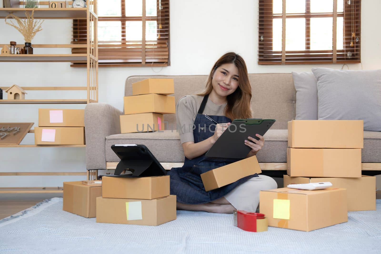 Portrait of Starting small businesses SME owners female entrepreneurs working on receipt box and check online orders to prepare to pack the boxes, sell to customers