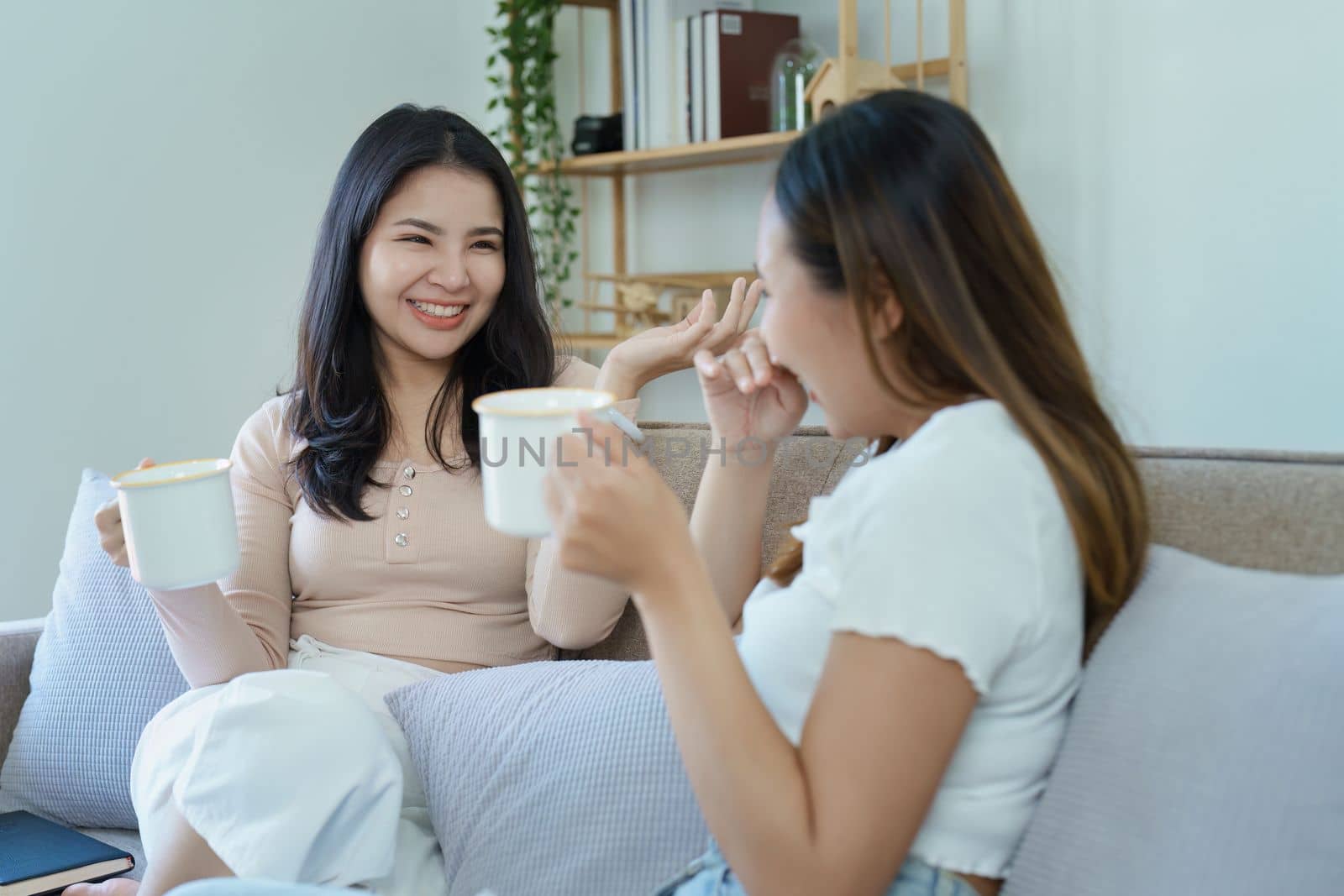 lgbtq, LGBT concept, homosexuality, portrait of two Asian women posing happy together and showing love for each other while having coffee at the dining table by Manastrong