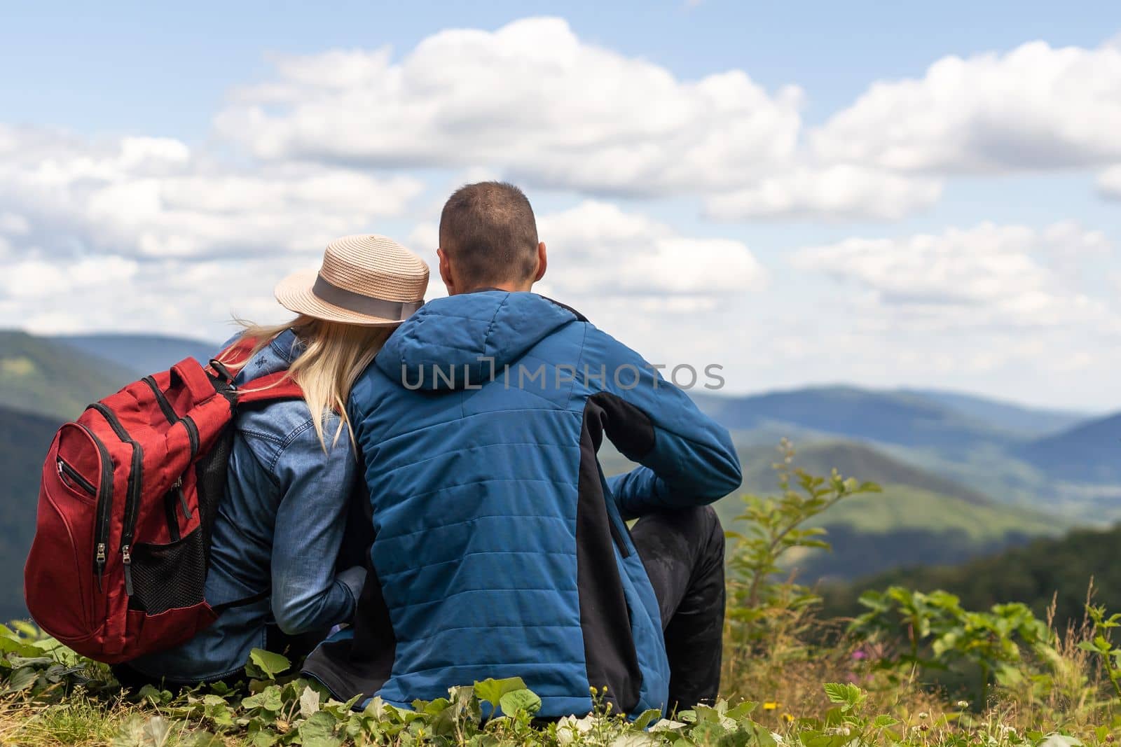 Portrait of beautiful young couple enjoying nature at mountain peak. by Andelov13