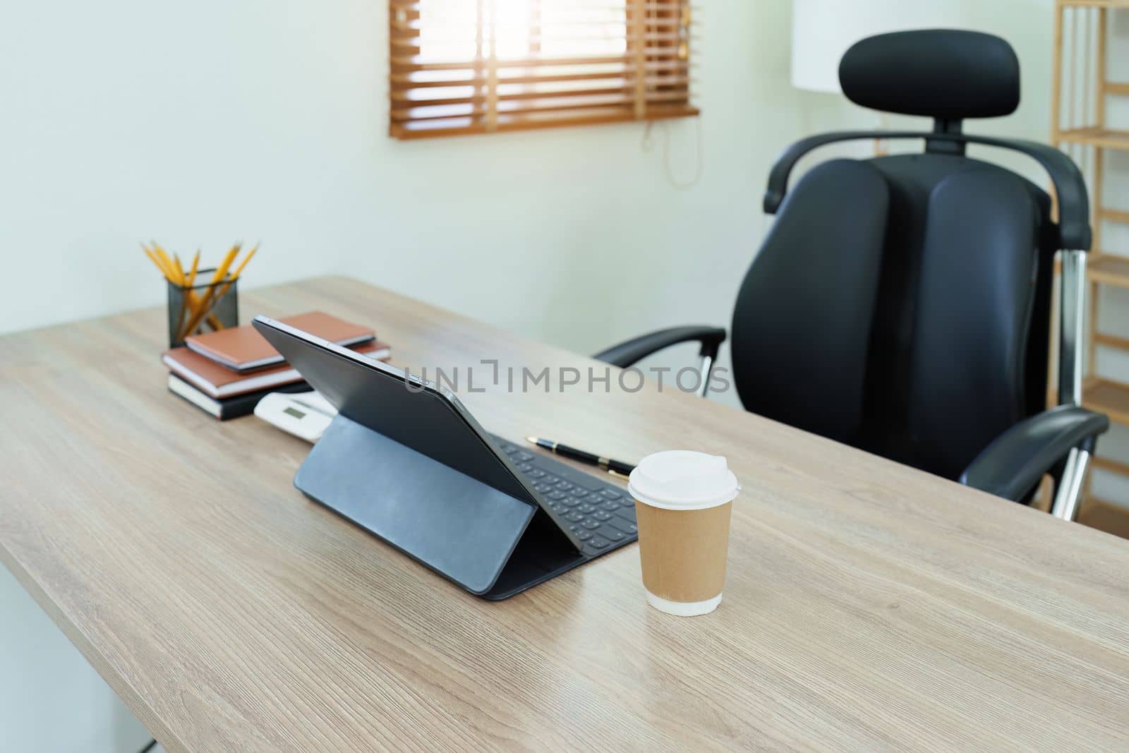 Tablet computer, notebook, calculator and coffee cup on the desk in the office by Manastrong