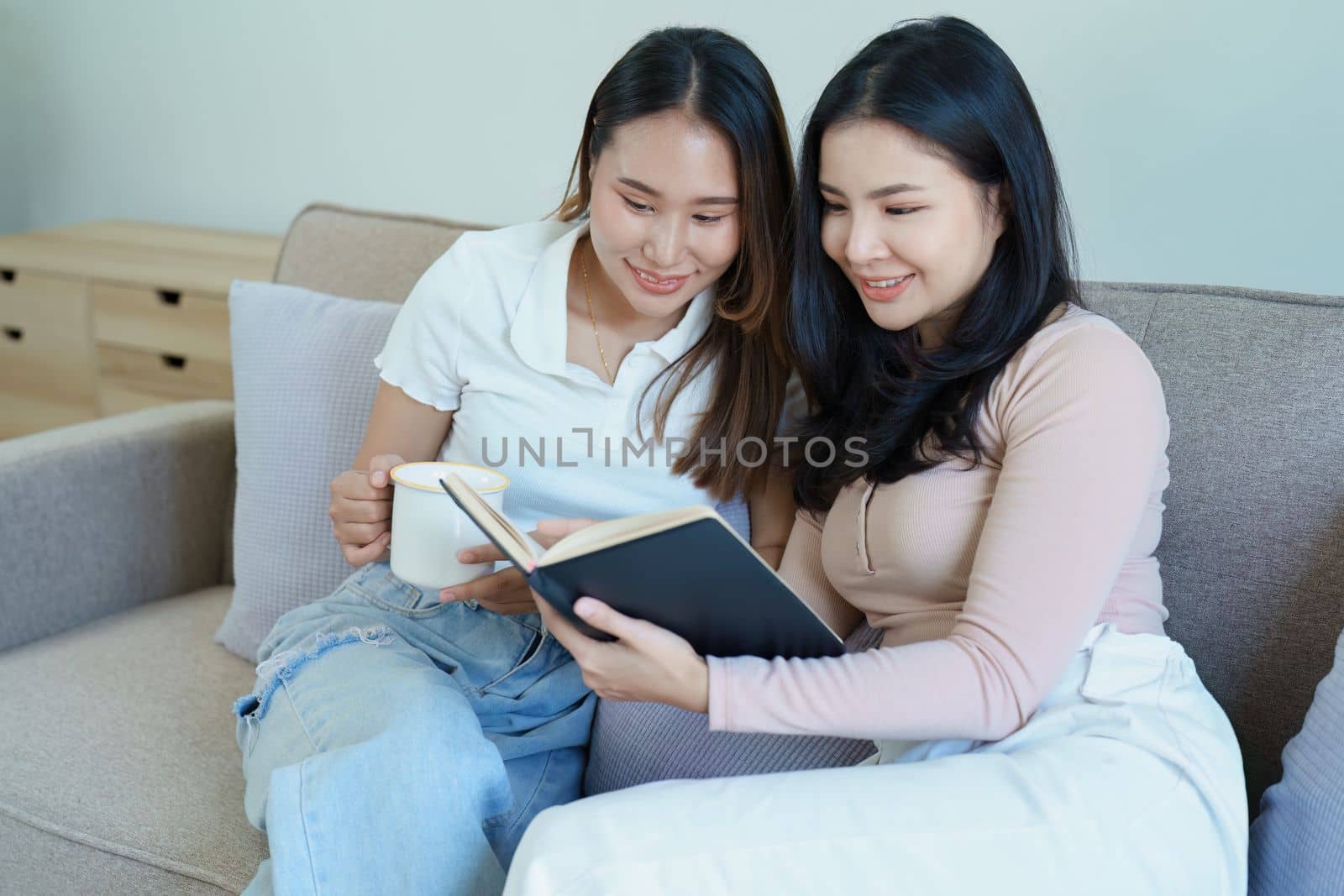 lgbtq, LGBT concept, homosexuality, portrait of two Asian women posing happy together and showing love for each other while having coffee at the dining table.